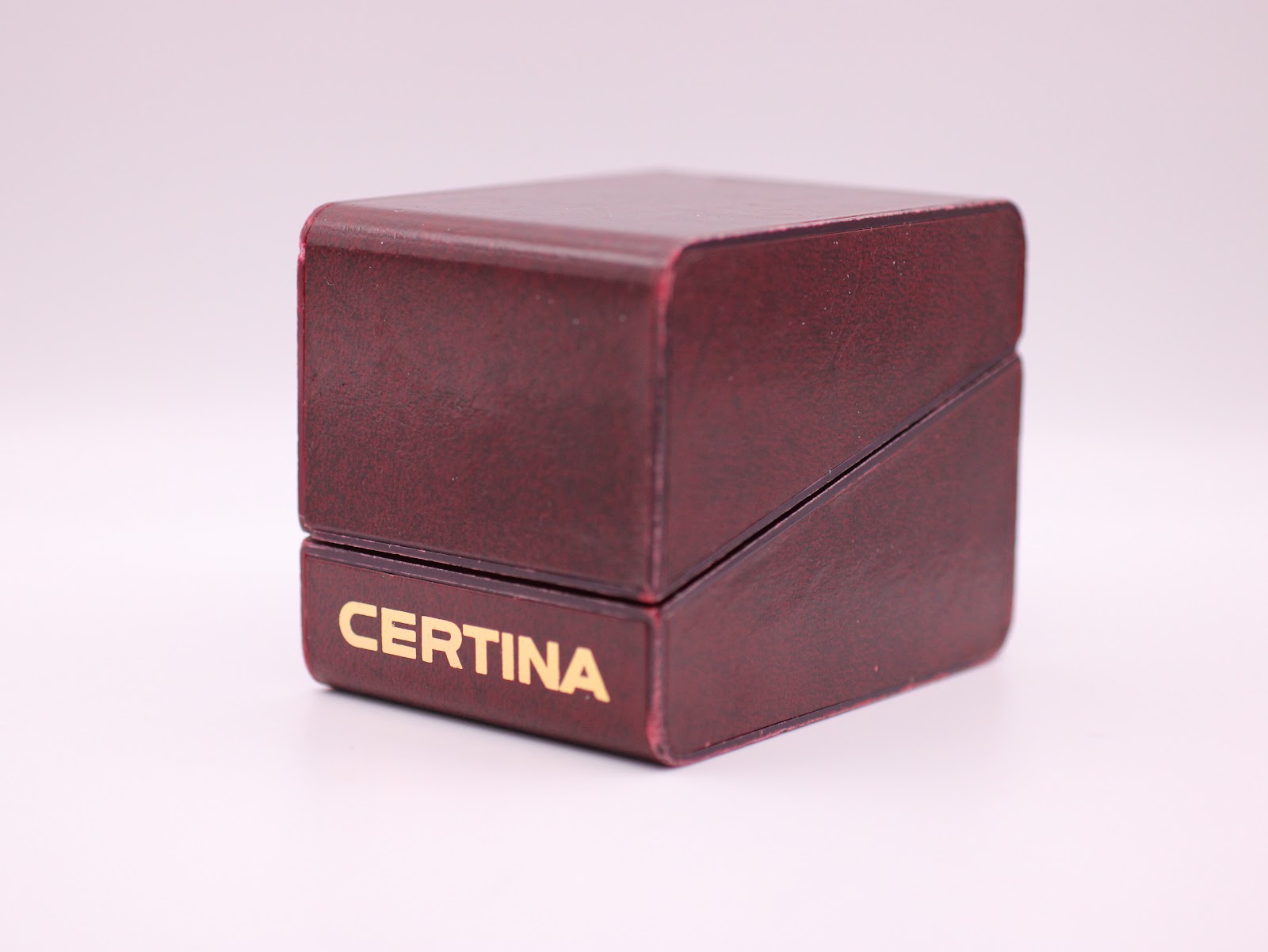 Closed view of the original dark red Certina presentation box with Certina logo.