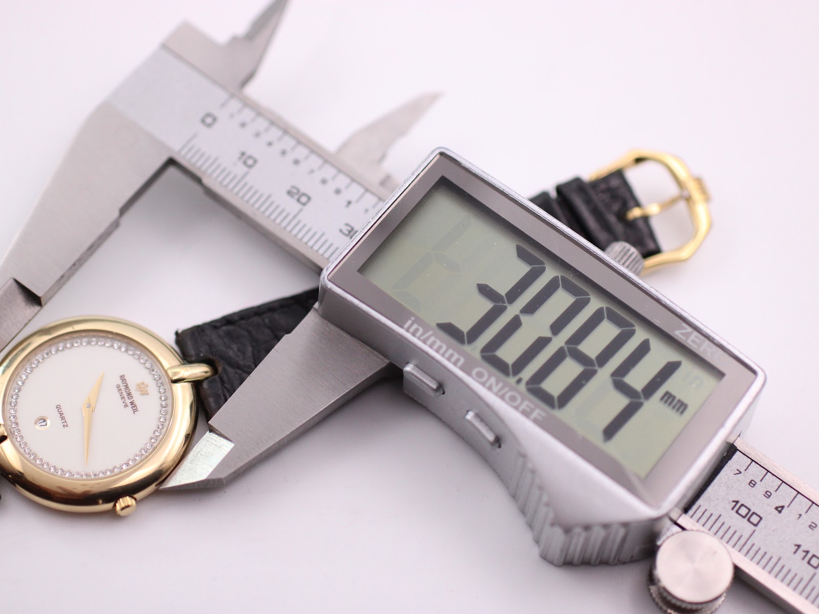 Digital caliper measuring the case diameter of the watch, displaying 30.84mm on its screen.