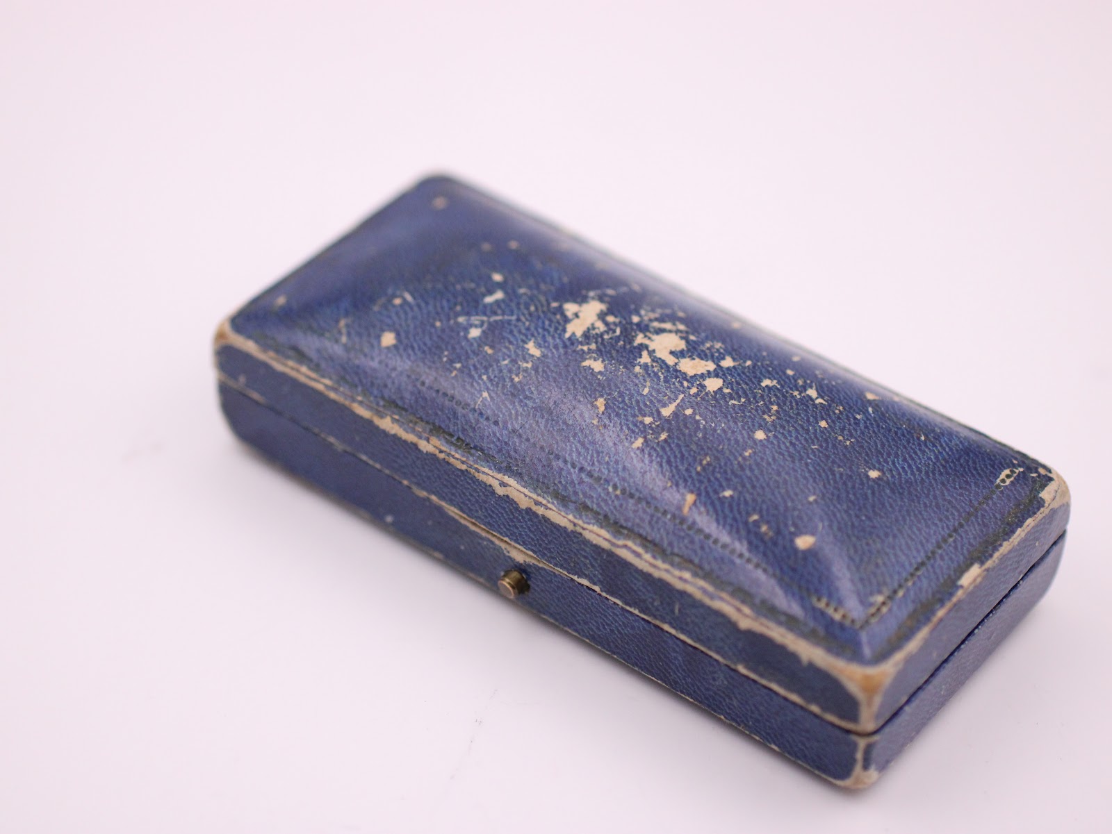 Exterior shot of the closed original vintage blue F. Hinds Ltd. presentation box, showing its aged textured surface.