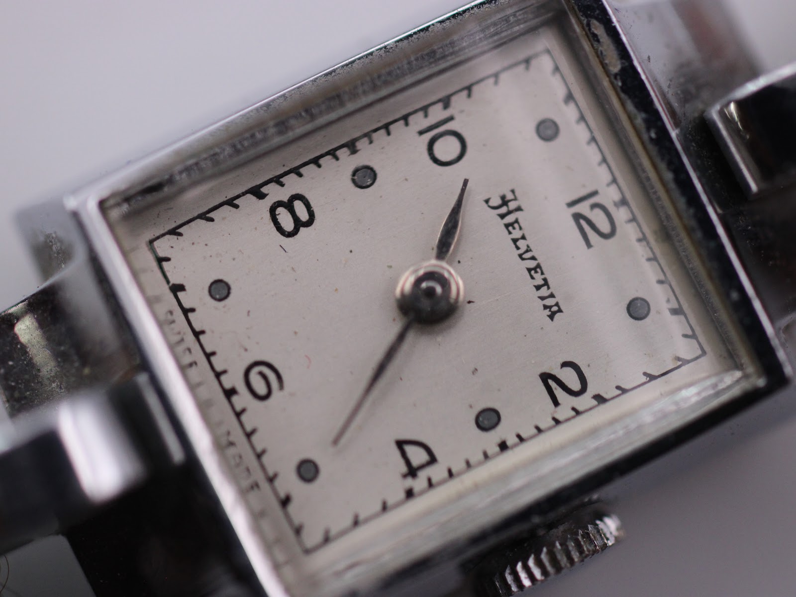 Extreme close-up on the Helvetia cream dial, showing the intricate details of the Arabic numerals, dot hour markers, and the 'Helvetia' brand name.
