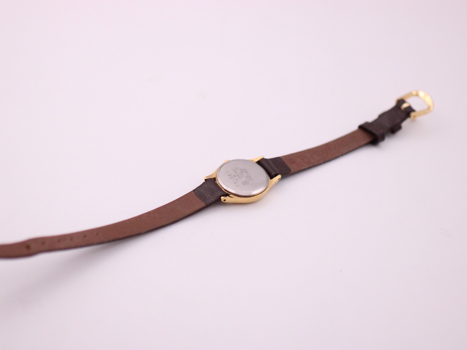 Bottom-up view of the Seiko watch laid flat, showing the stainless steel case back and the strap.