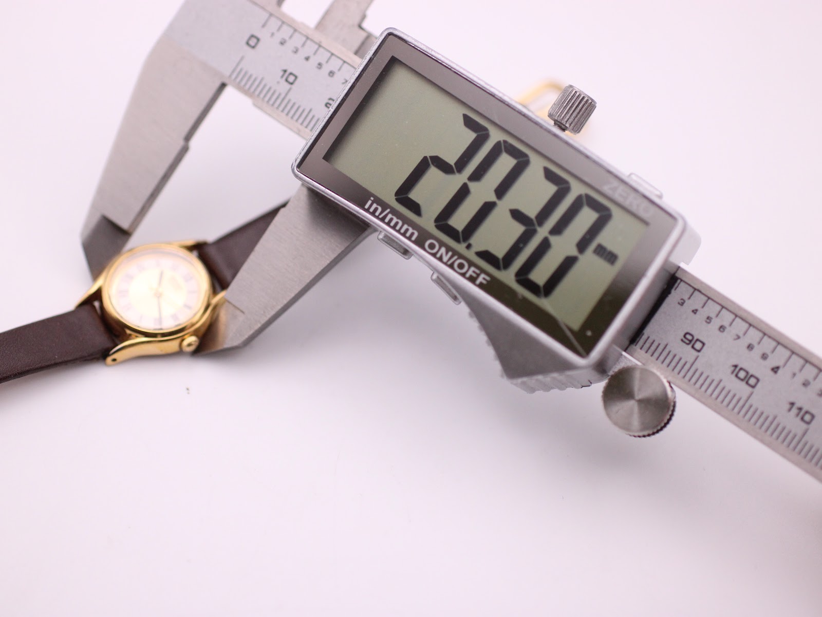 Digital caliper measuring the case diameter of the Seiko watch, showing 20.30mm on the display.