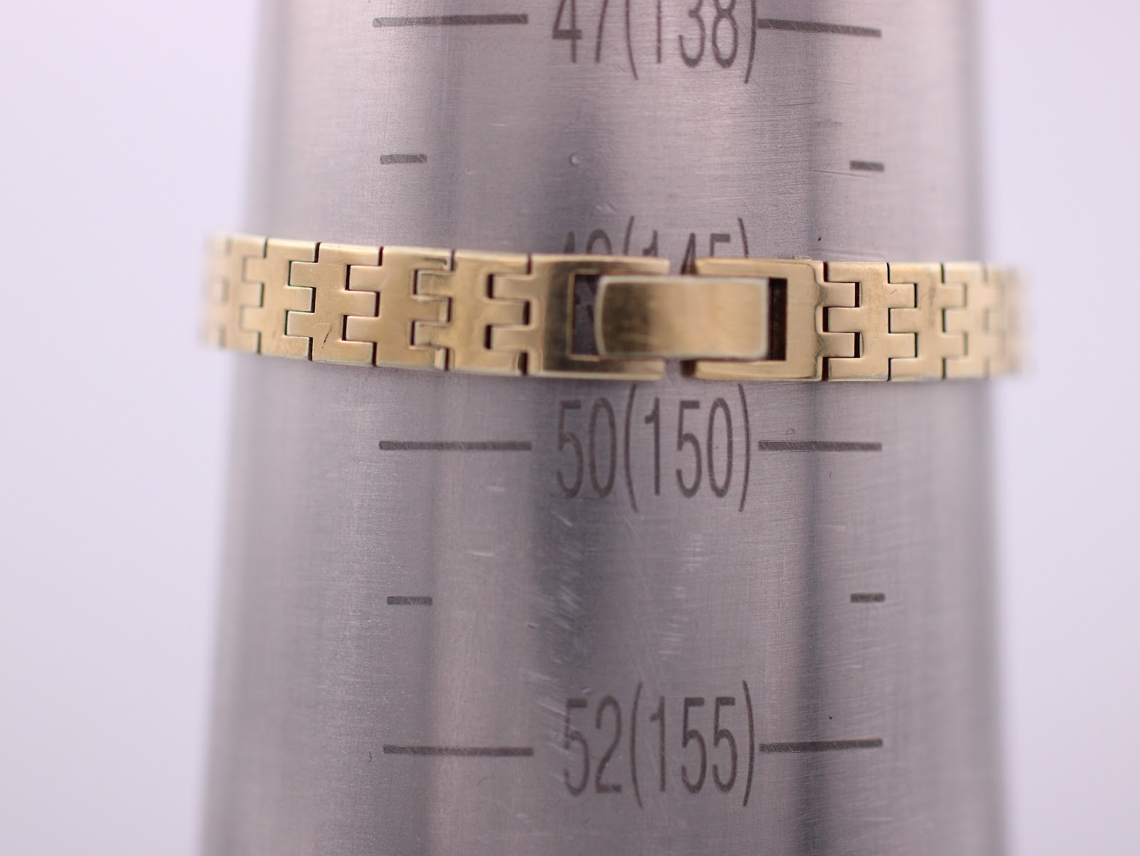 The watch bracelet displayed on a wrist sizing gauge, indicating an approximate wrist circumference measurement.