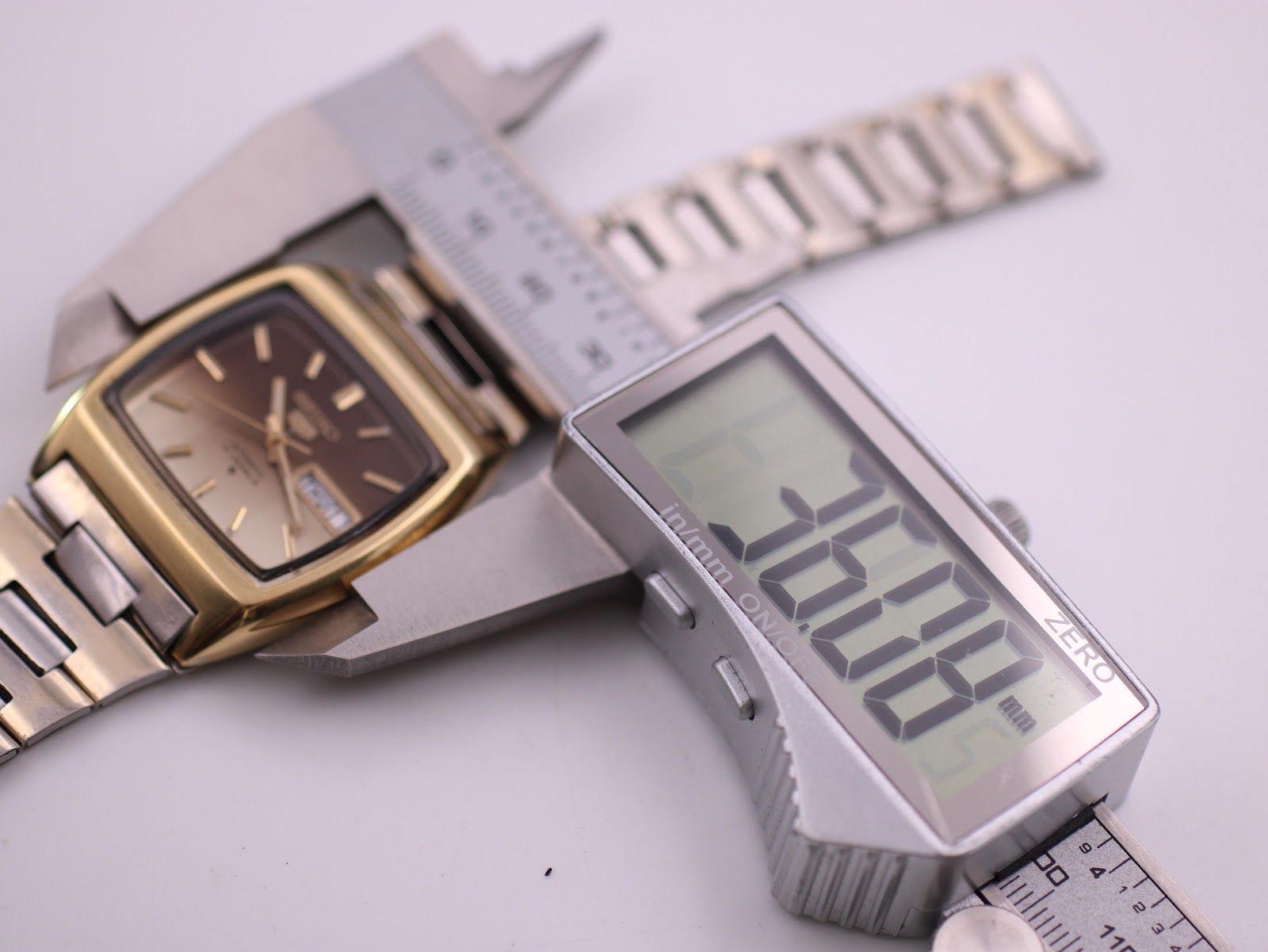 Digital caliper measuring the case diameter of the Seiko watch, displaying an exact measurement of 38.00 mm.
