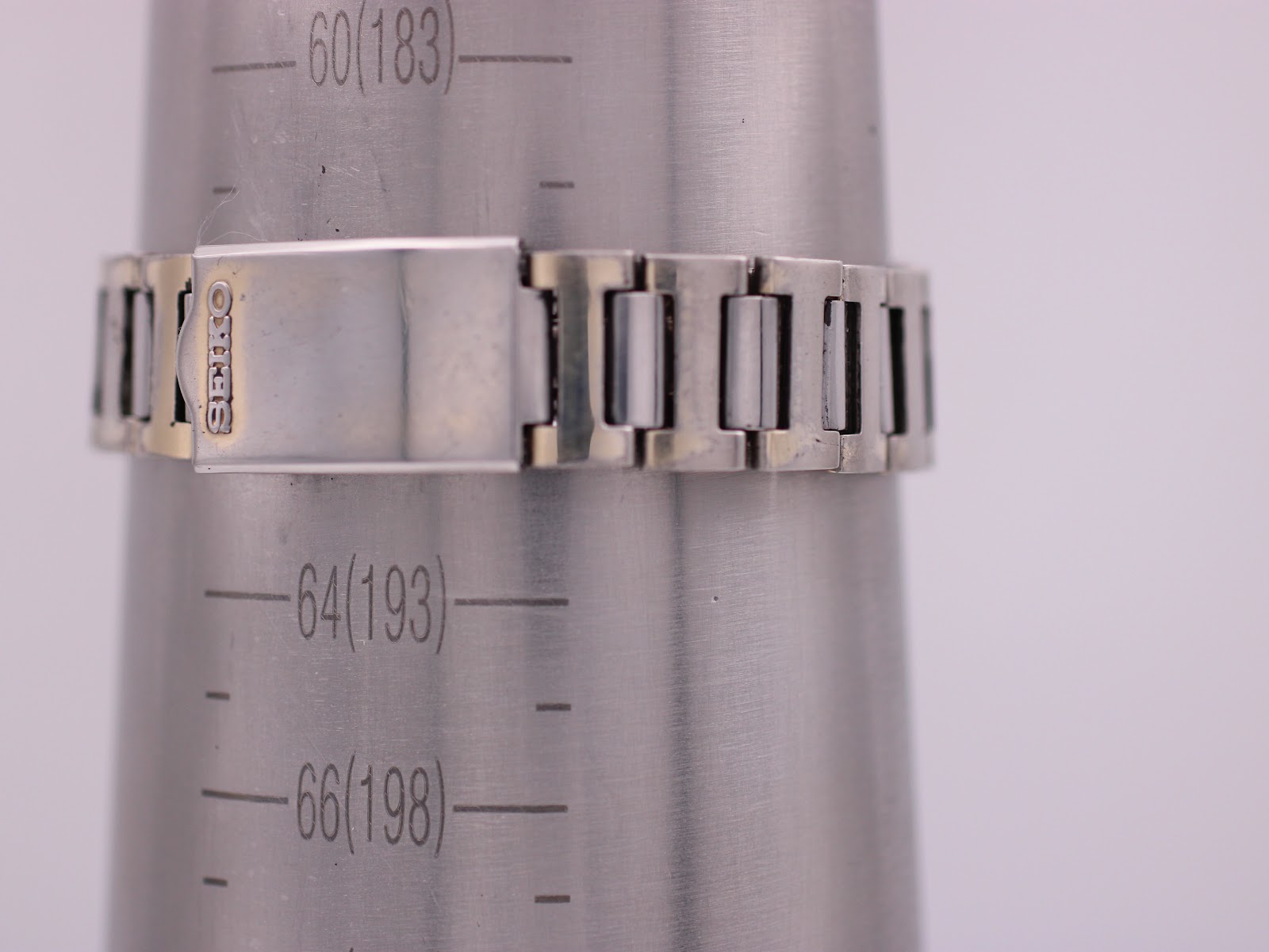 Seiko two-tone steel bracelet on a wrist sizing cone, showing a wrist circumference measurement of 183mm / 18.3cm and the signed clasp.