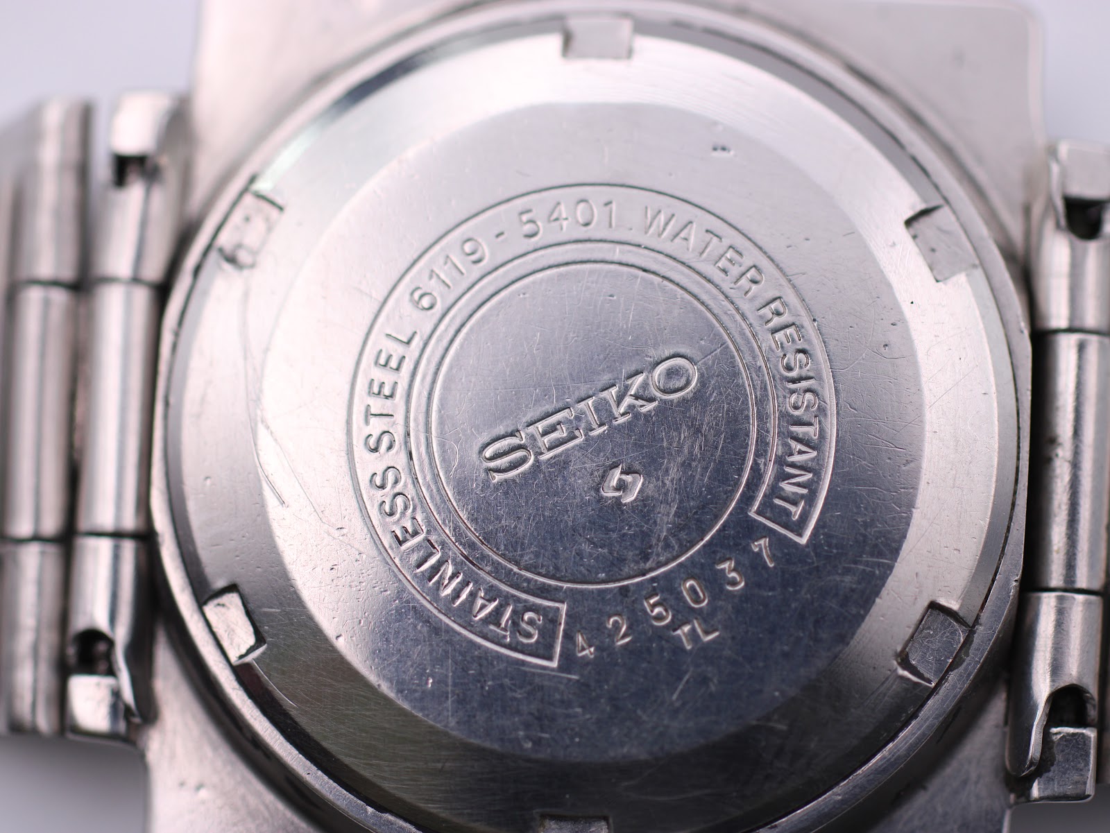 Detailed close-up of the Seiko 6119-5401 case back engraving, showing model 6119-5401, serial 425037, and 'Water Resistant'.