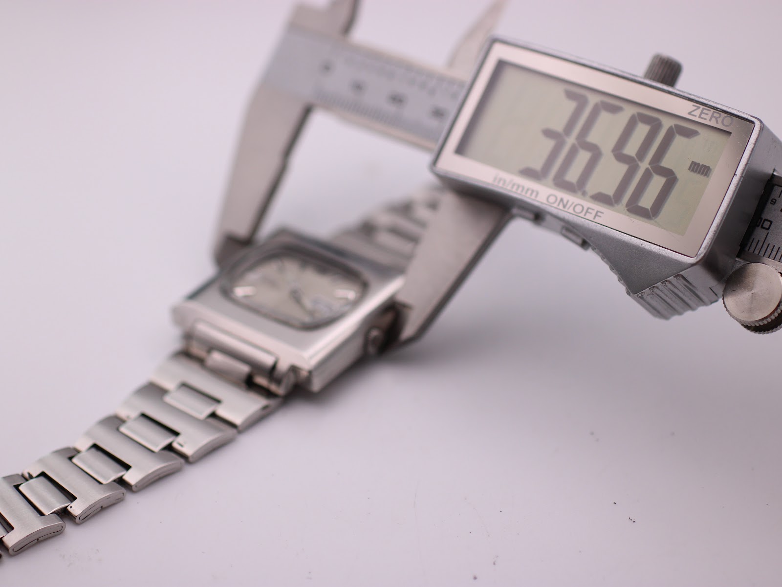 Digital caliper measuring the case width of the Seiko 6119-5401, displaying 36.96mm.