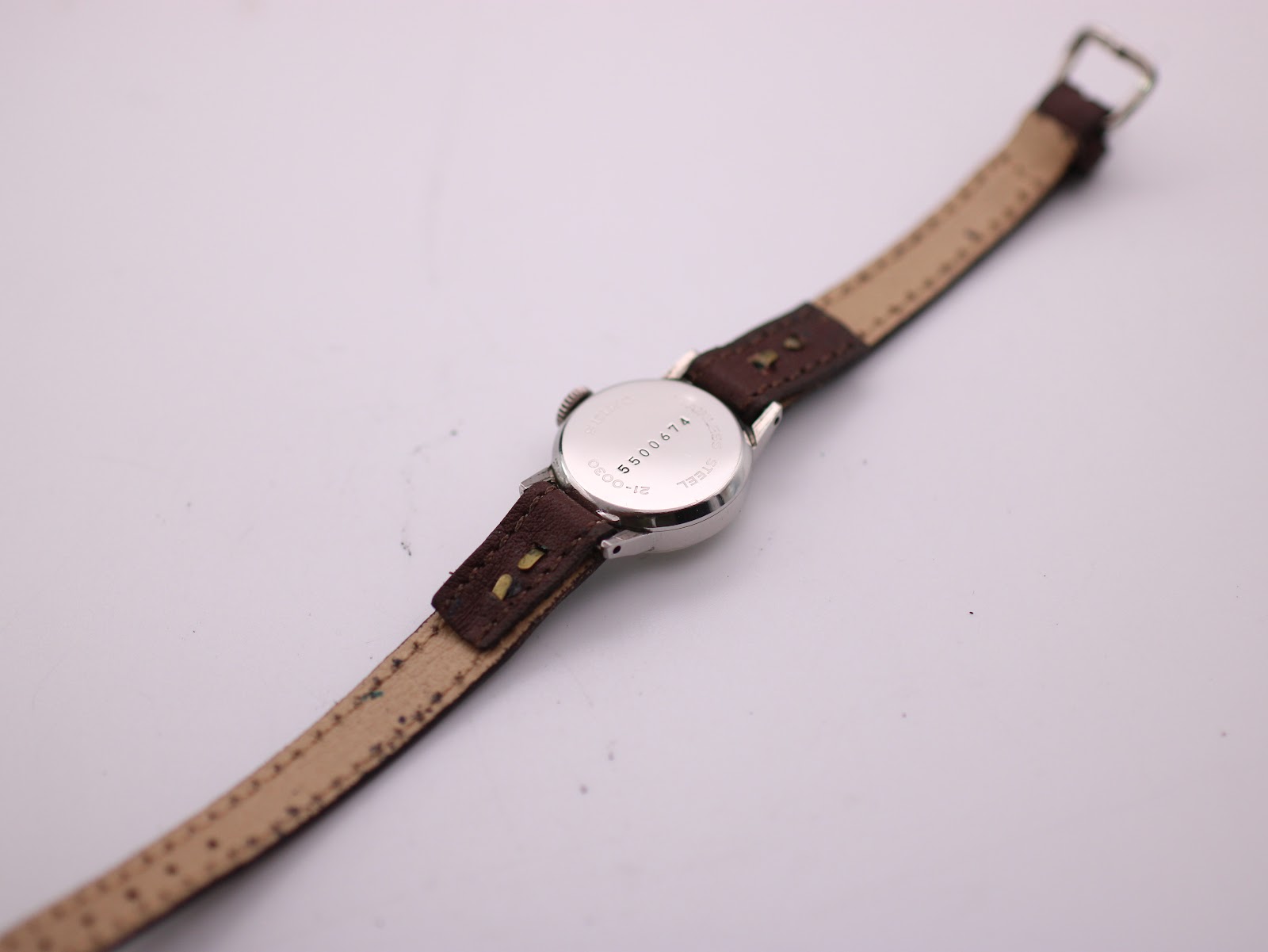 Rear view of the Seiko watch, showing the case back with serial number and strap laid out.
