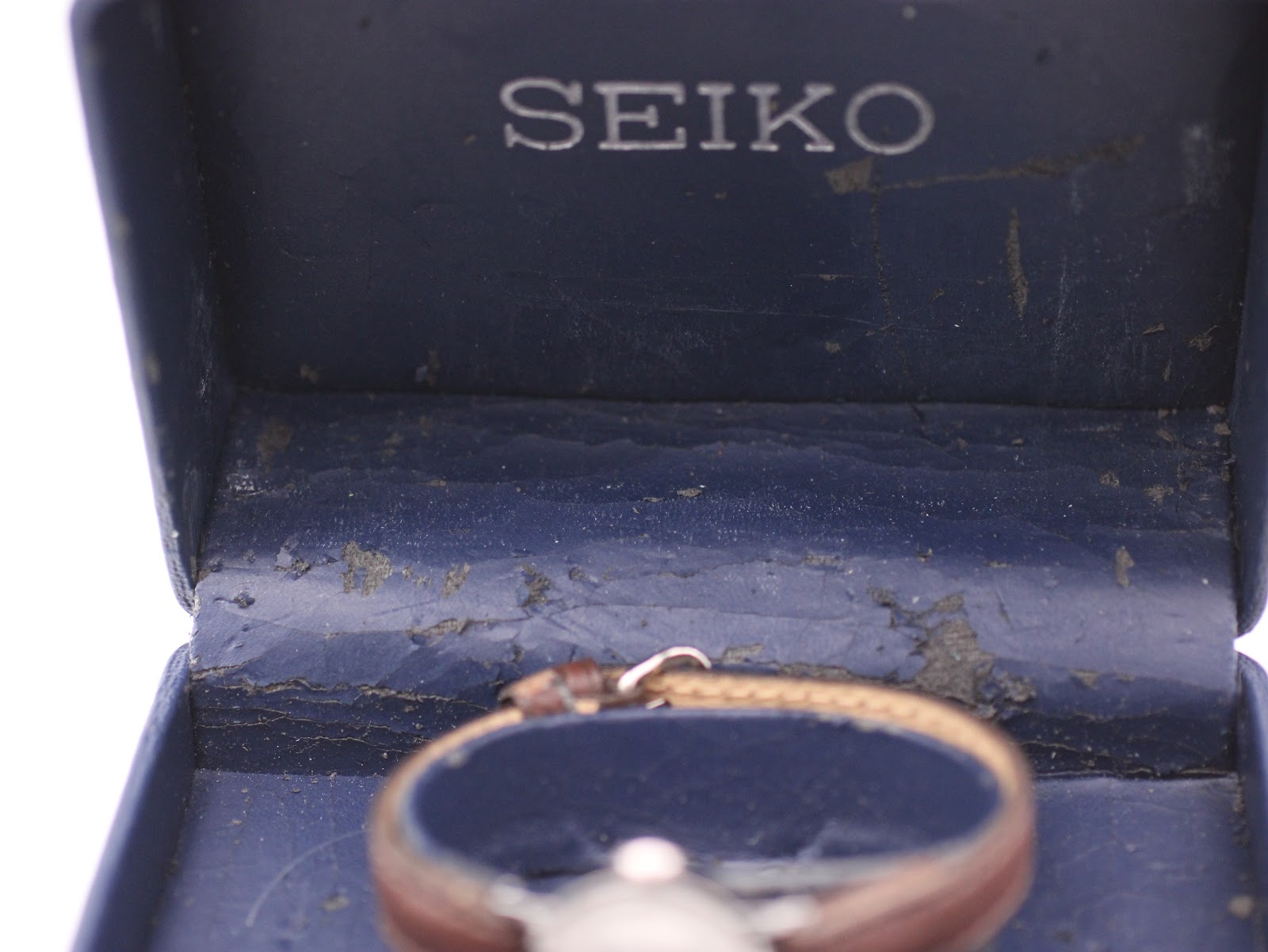 Close-up of the interior of the original blue Seiko box, showing the 'SEIKO' logo and worn fabric.