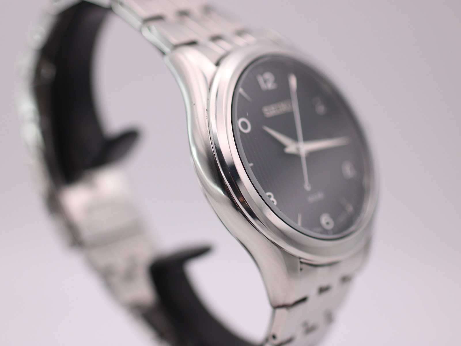 Opposite angled side view highlighting the curved lugs and stainless steel bracelet.