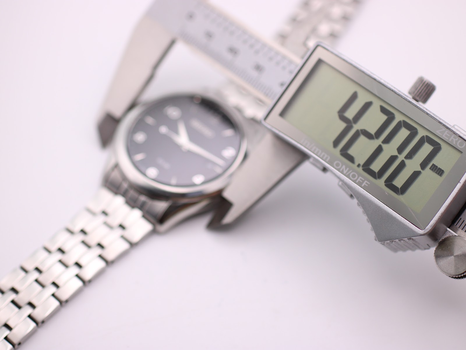 Digital caliper measuring the case diameter of the watch, displaying 42.00mm.