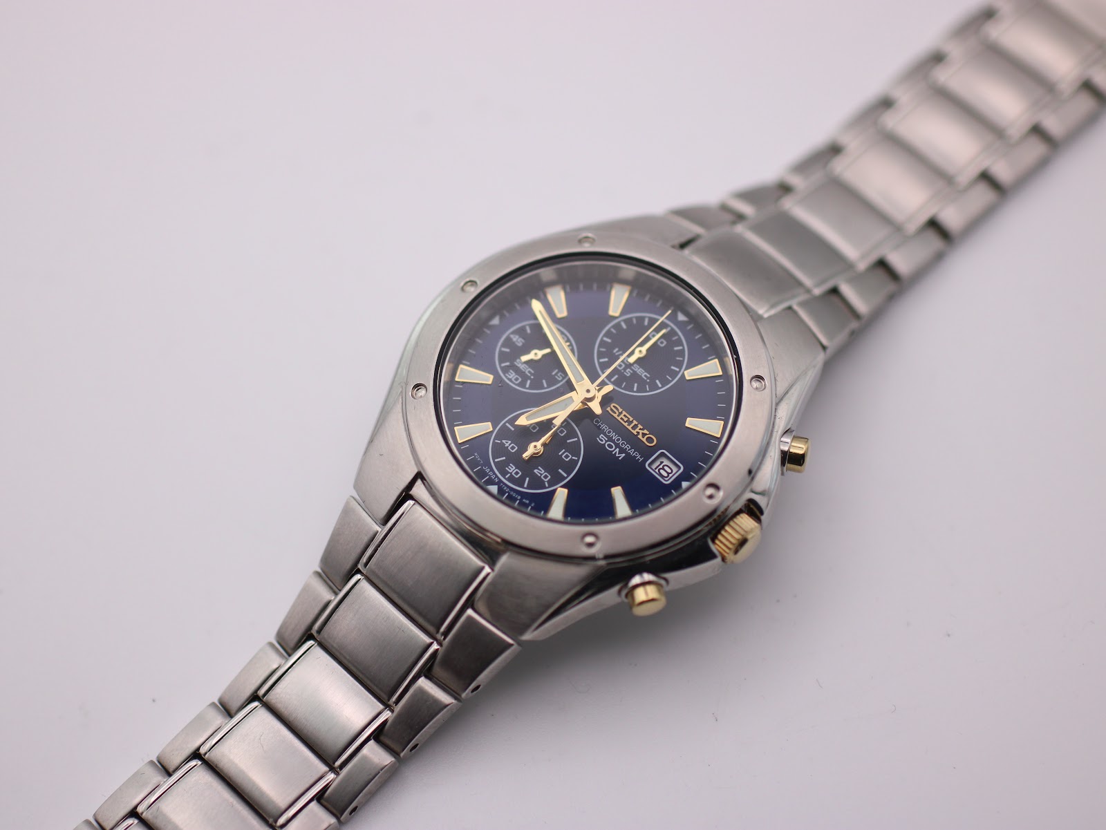 Top-down view of the Seiko 7T92-0FX0 chronograph on a white background, showcasing the complete watch.