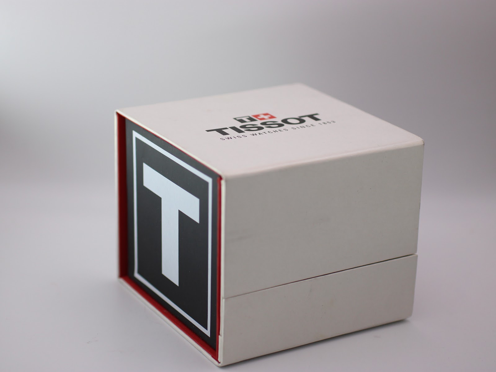 Top and side view of the closed original Tissot branded red and white presentation box.