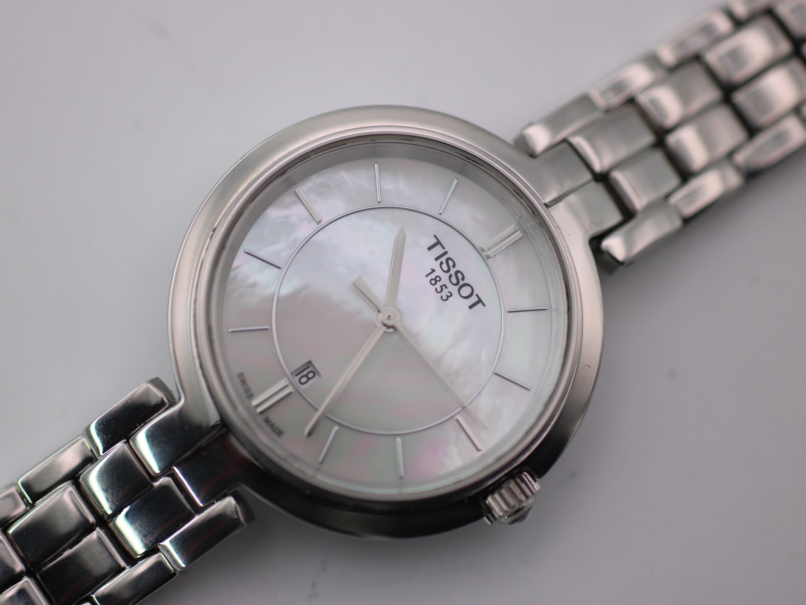 Slightly angled close-up of the Tissot dial and polished stainless steel case, showing the subtle reflections on the dial.