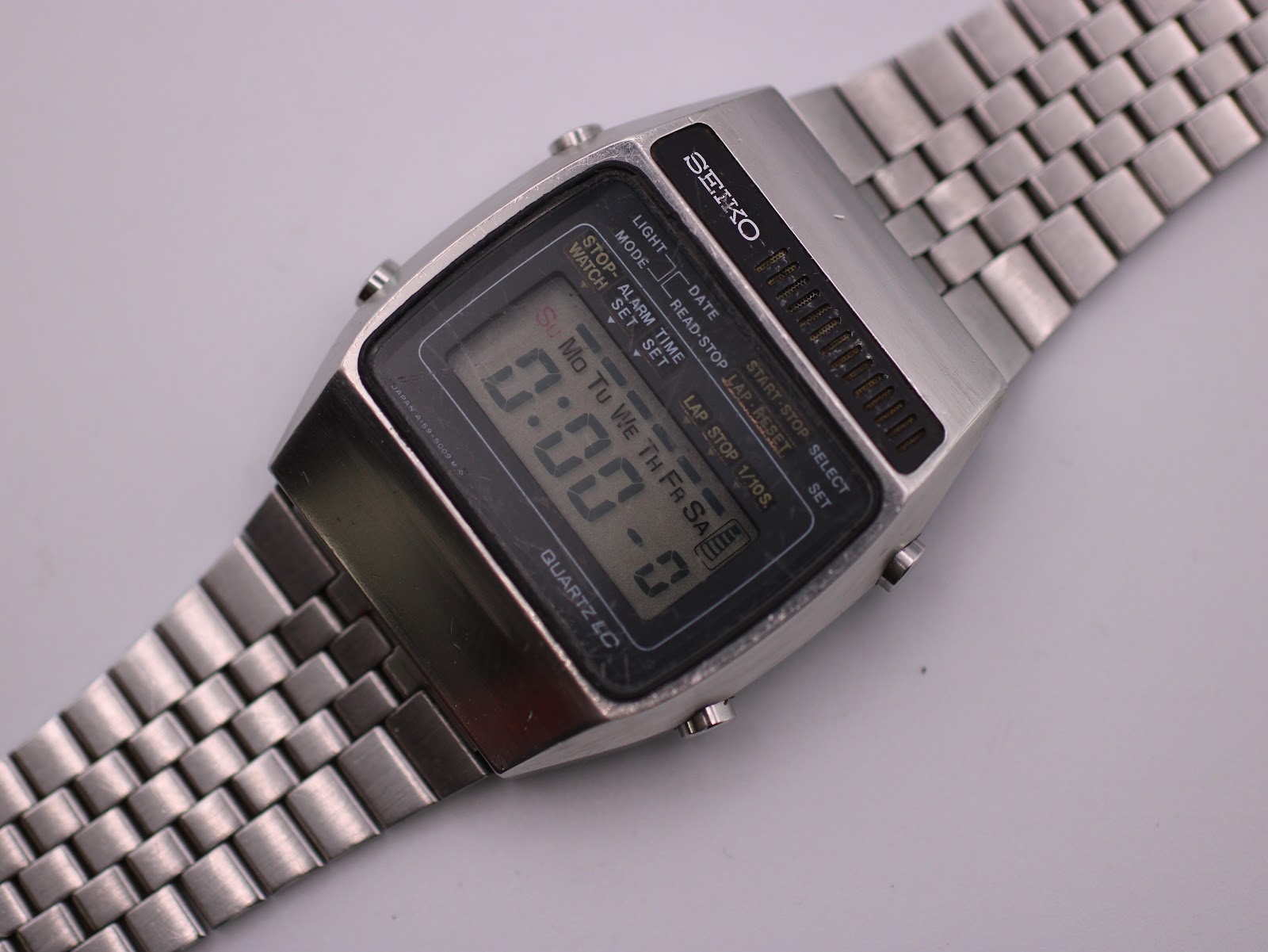 Close-up angled view of the Seiko A159-5009-G dial, showing the digital display at 0:00:00, with text 'QUARTZ LC' and various mode indicators.