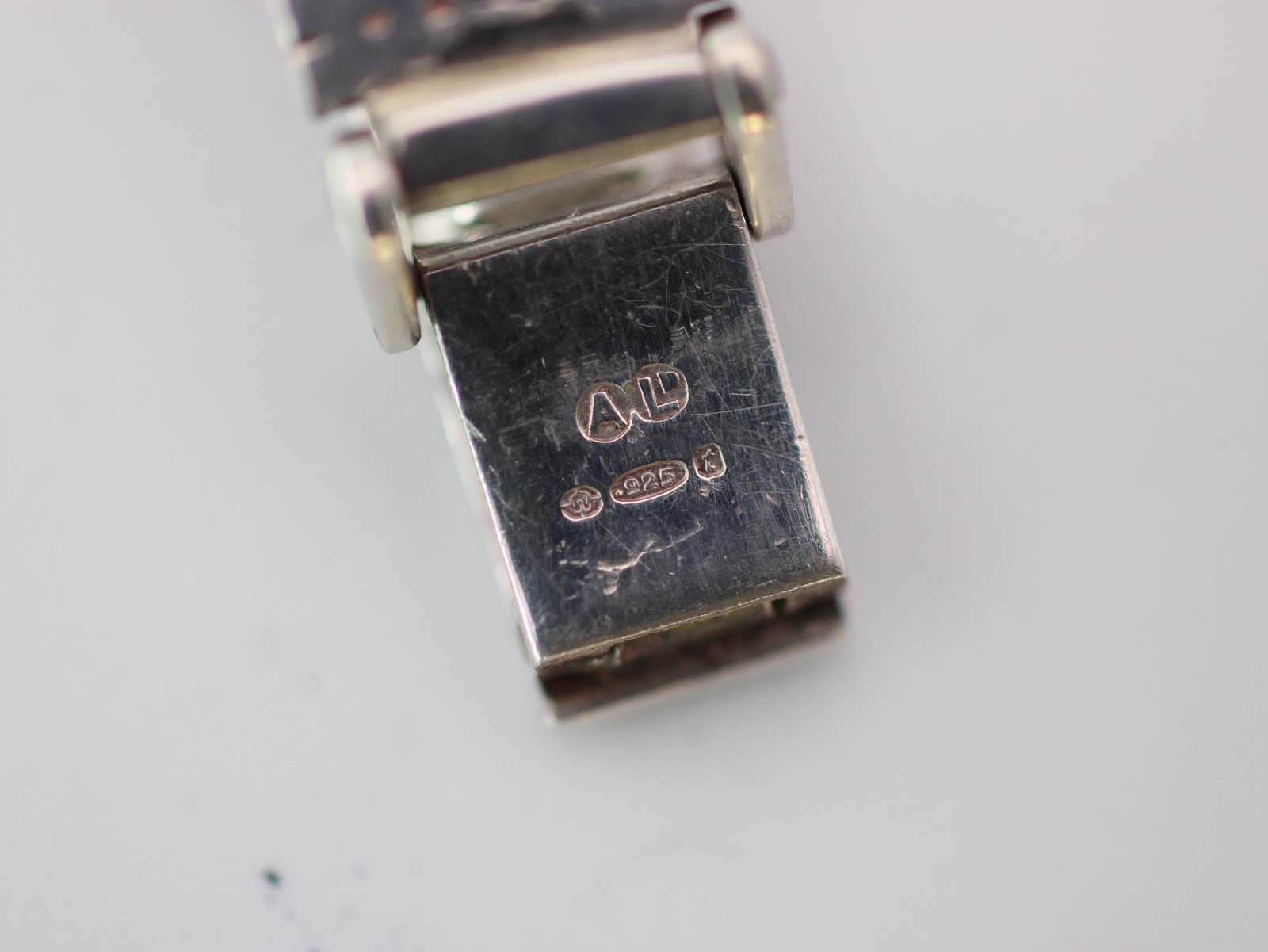 Close-up of the bracelet clasp, displaying a '925' sterling silver hallmark and a maker's mark.