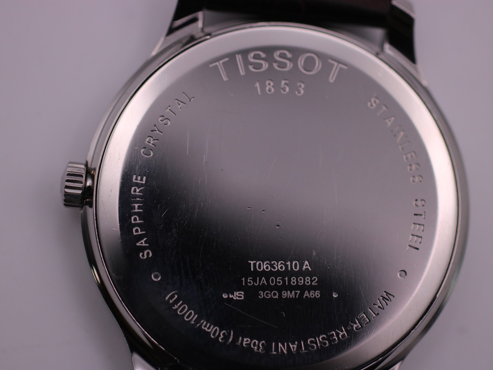 Detailed close-up of the stainless steel case back, displaying Tissot branding, model T063610 A, serial number, "Sapphire Crystal", and "Water-Resistant 3bar (30m/100ft)" engravings.