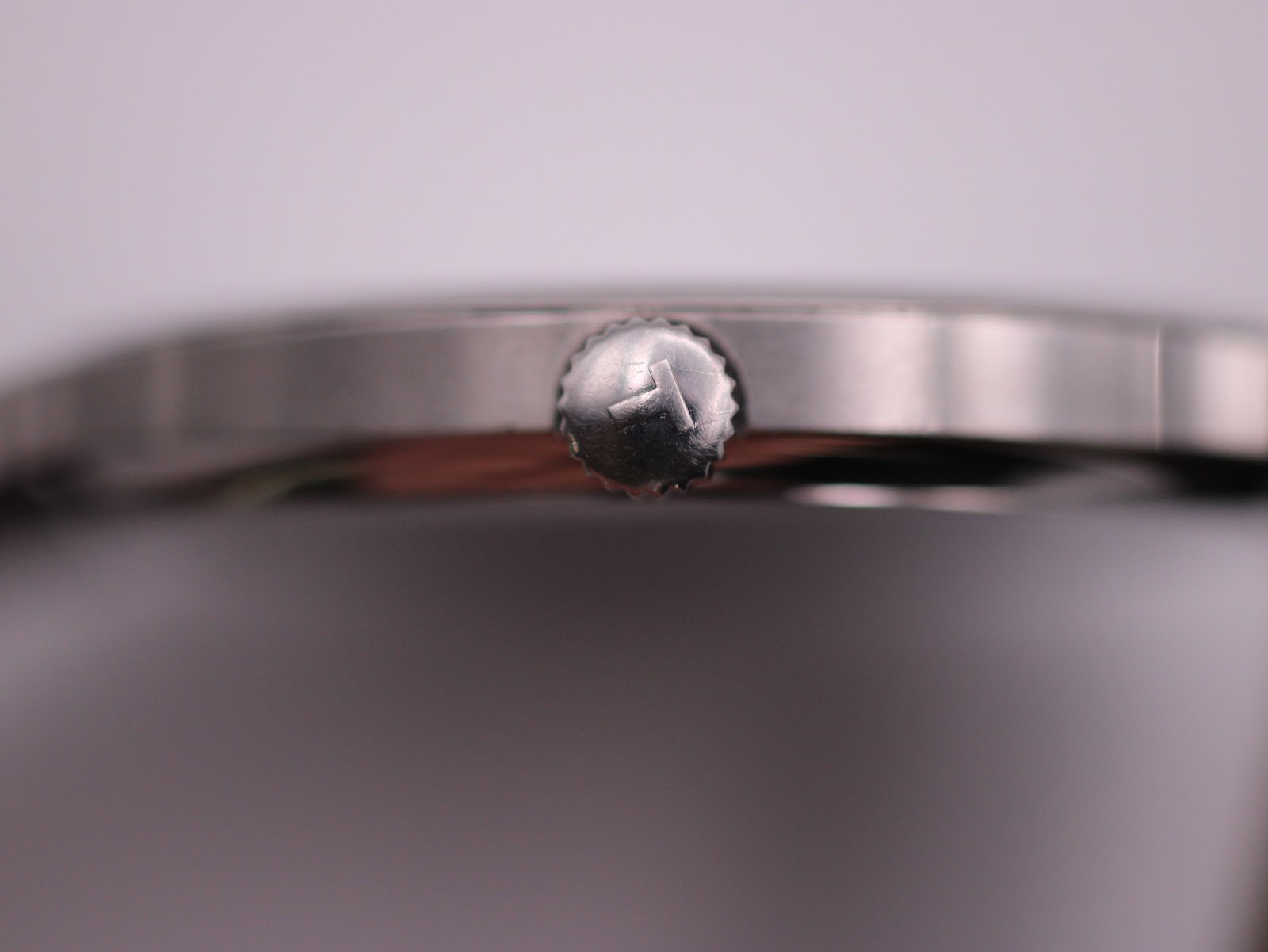 Close-up of the watch crown, featuring the iconic Tissot 'T' logo.