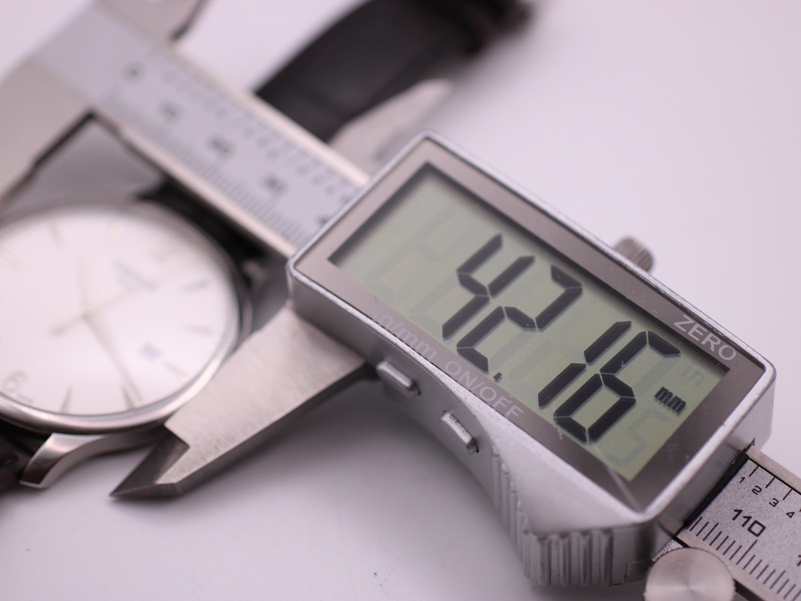 Digital caliper measuring the Tissot watch case, showing a precise diameter of 42.16mm.