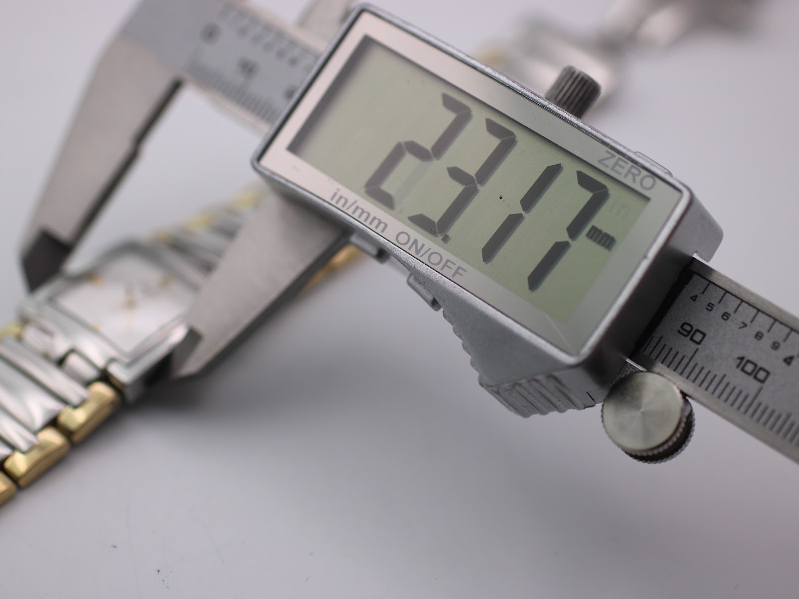 Digital caliper measuring the case diameter of the Tissot watch, clearly displaying a measurement of 23.17mm.
