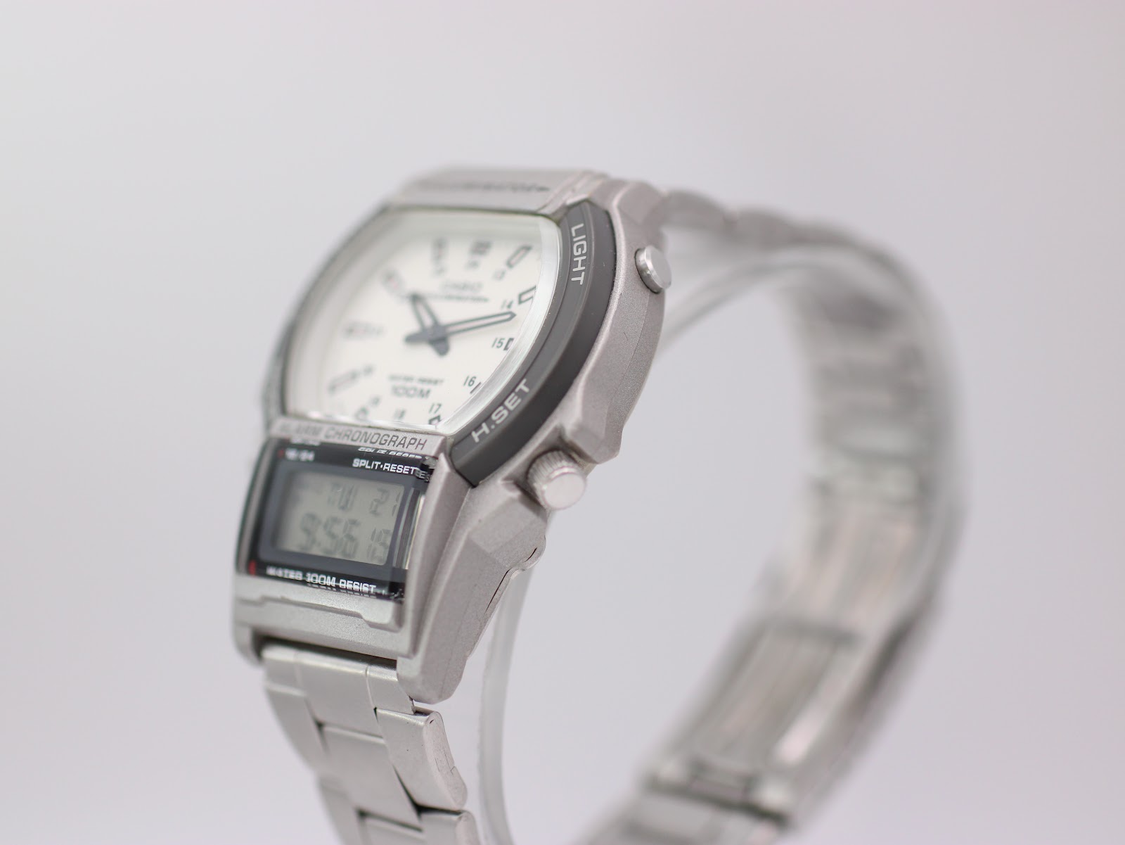 Right side view of Casio AW-61 watch on stand, showing the 'light' button and crown details.
