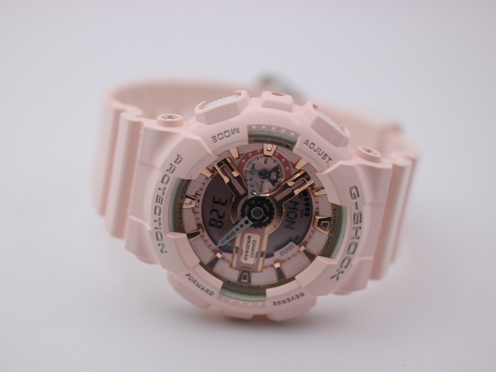 Angled top-down view of the pink G-SHOCK dial and case, highlighting the rose gold elements.