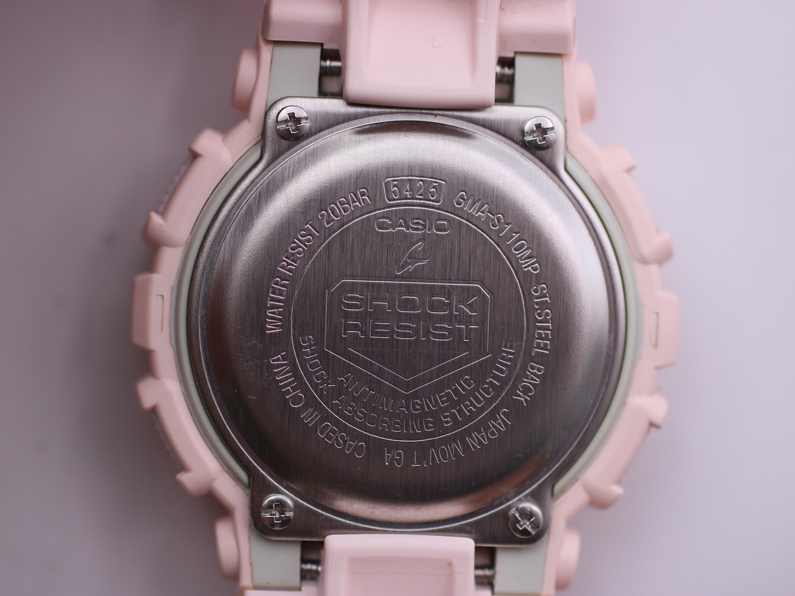 Close-up of the stainless steel case back with model number, water resistance, and "SHOCK RESIST" engraving.