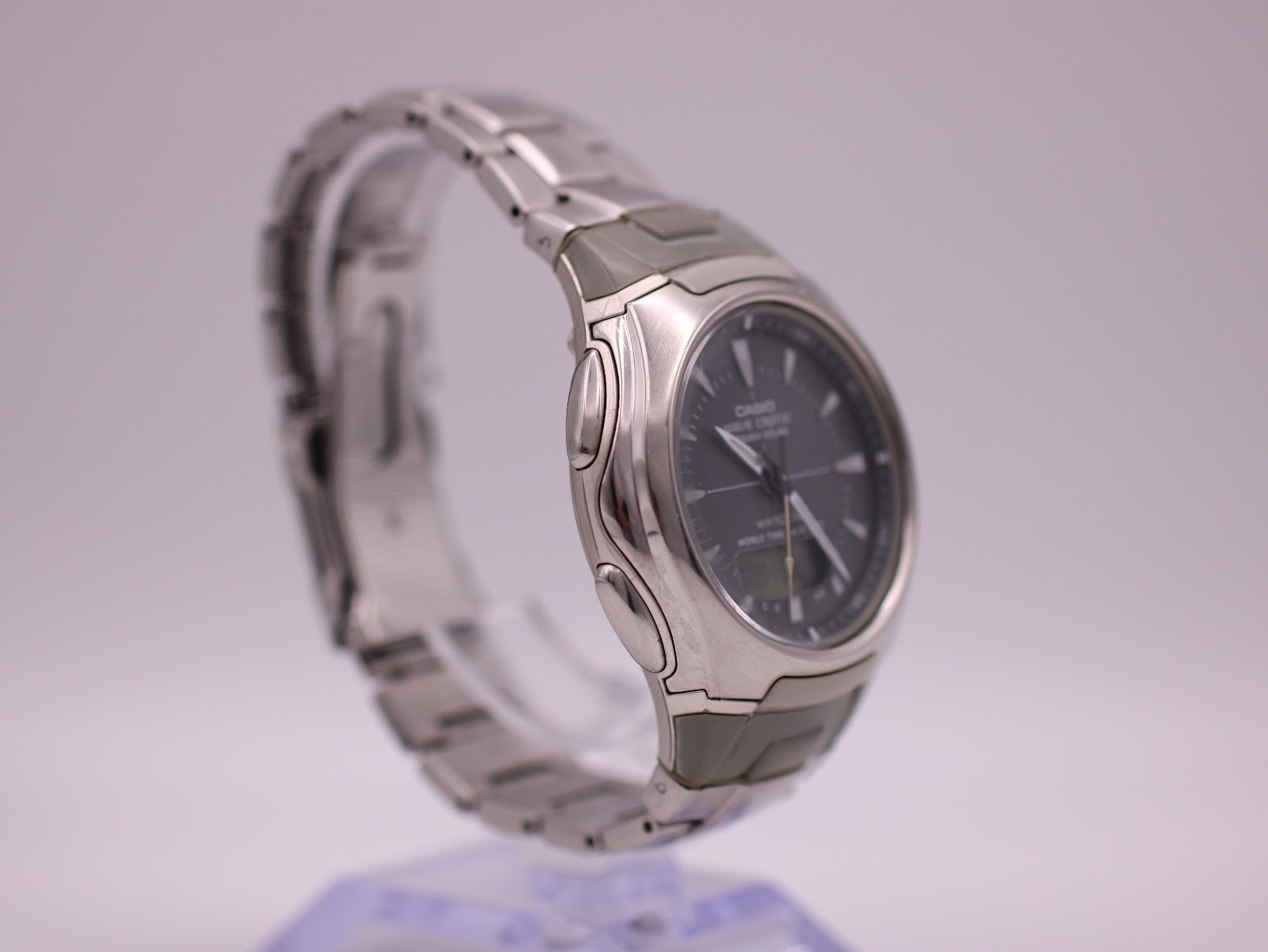 Right side view of the Casio Wave Ceptor watch on a display stand, highlighting the buttons and case shape.