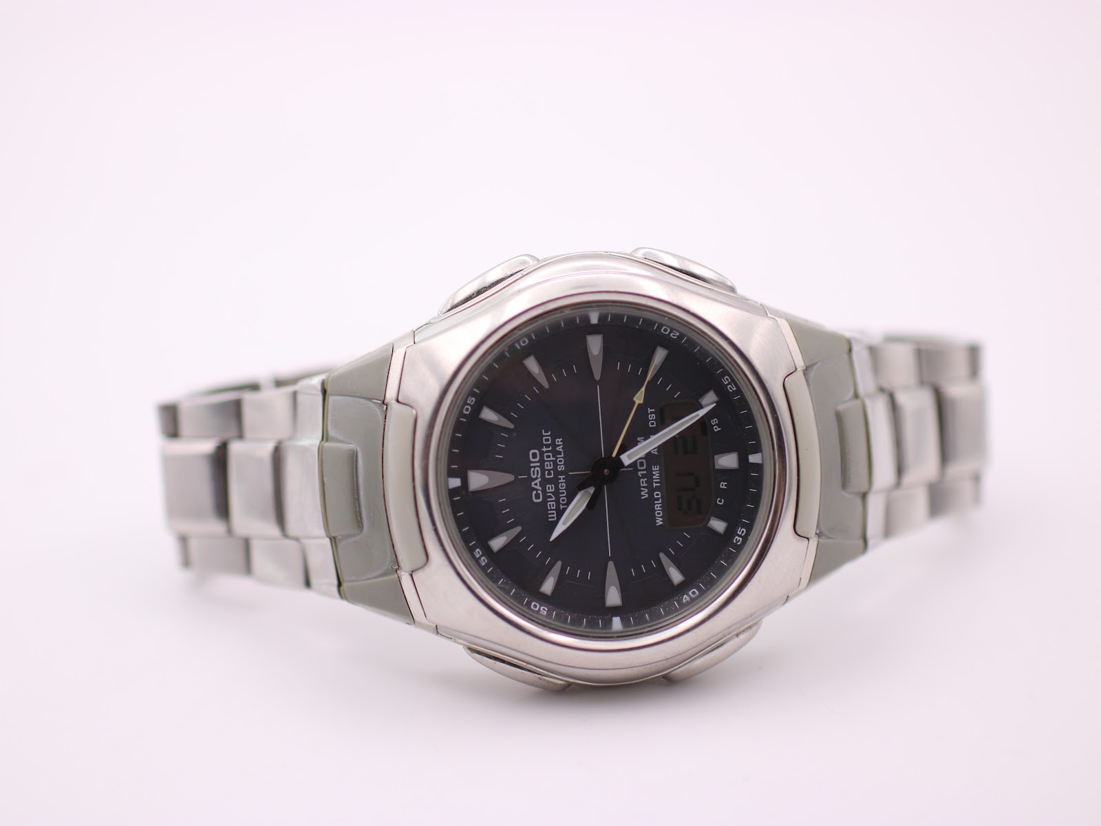 Angled front view of the Casio Wave Ceptor with the full silver steel and grey resin bracelet laid flat.