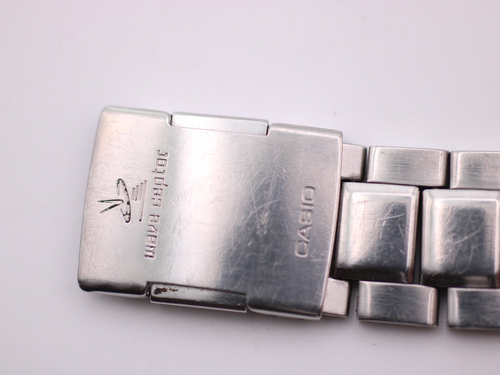 Another close-up of the Casio signed fold-over clasp on the steel bracelet, showing minor wear.