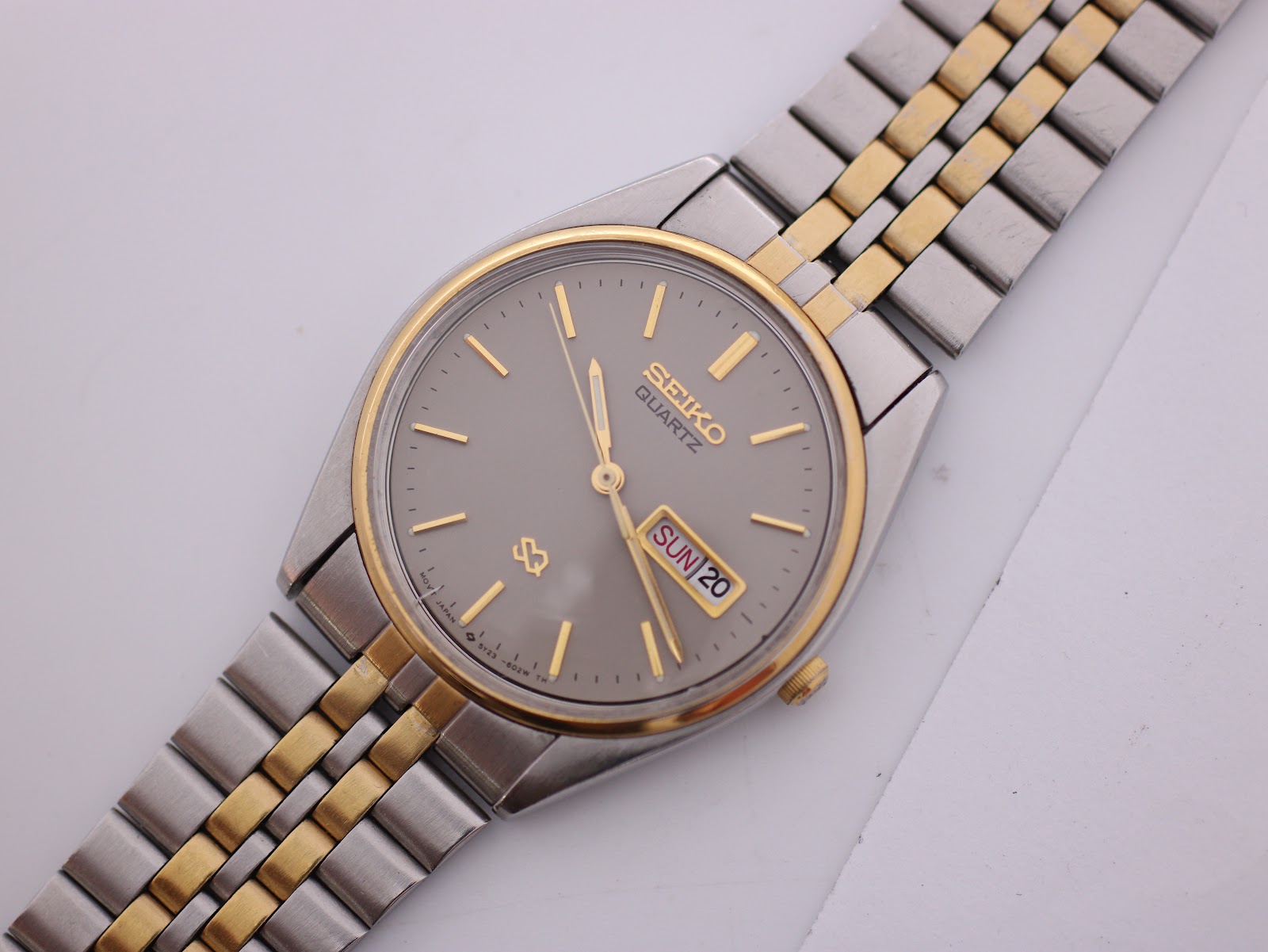 Overhead view of the Seiko 5Y23-6020 watch, showing the full two-tone bracelet and grey day-date dial.