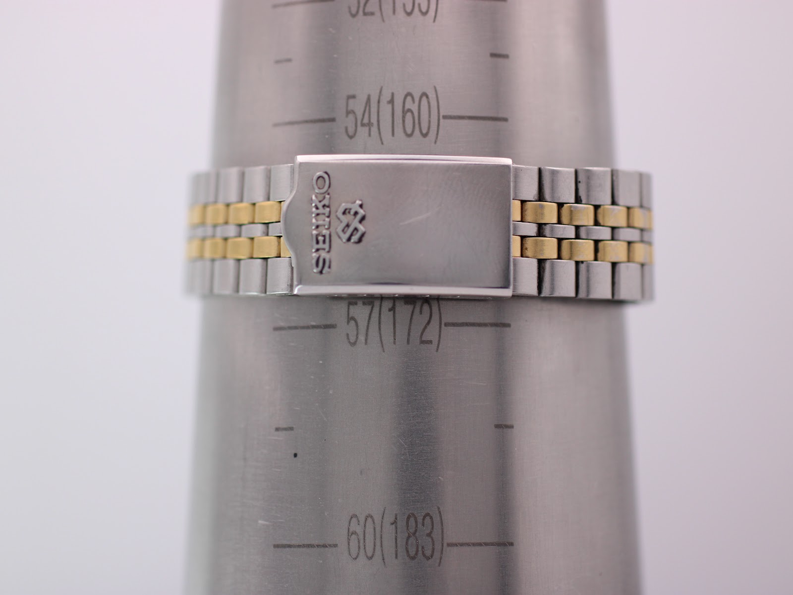 Close-up of the two-tone bracelet clasp on a wrist sizing cone, showing 'SEIKO' engraving and indicating a wrist size of approximately 17.2 cm.