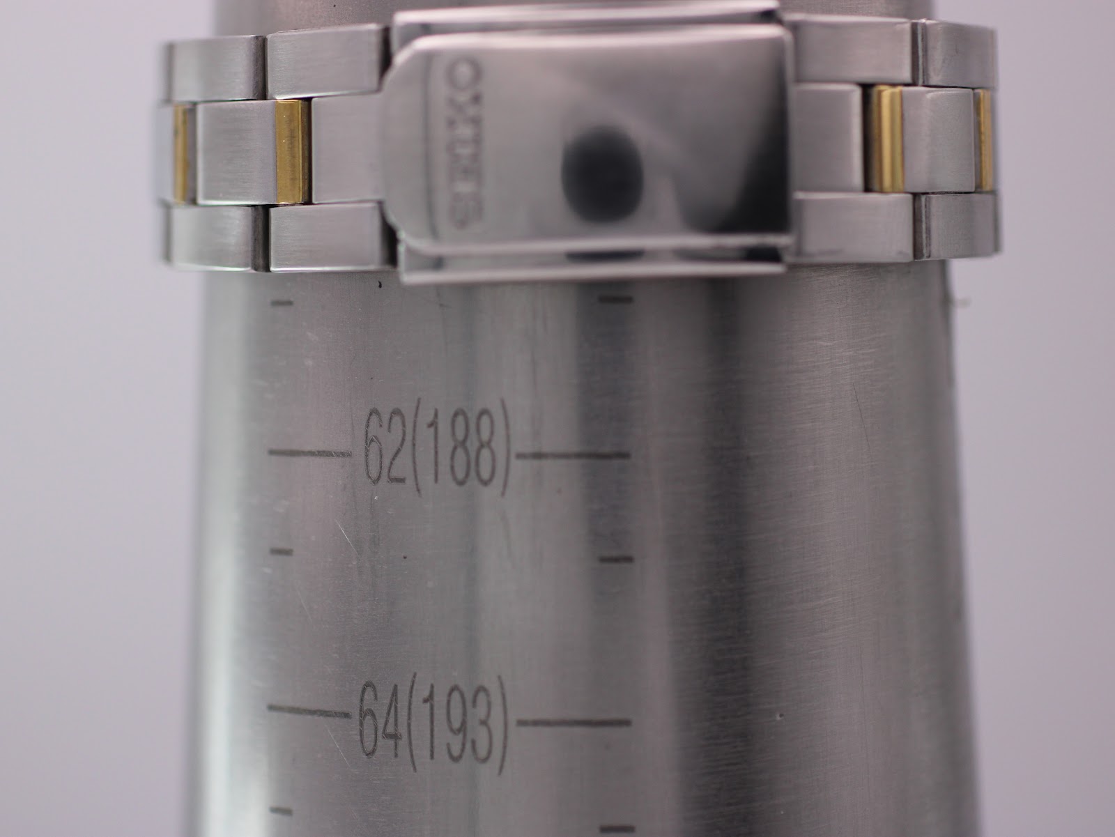Close-up of the two-tone Seiko bracelet and signed clasp on a metal wrist sizing cone, indicating a wrist size of approximately 188mm.