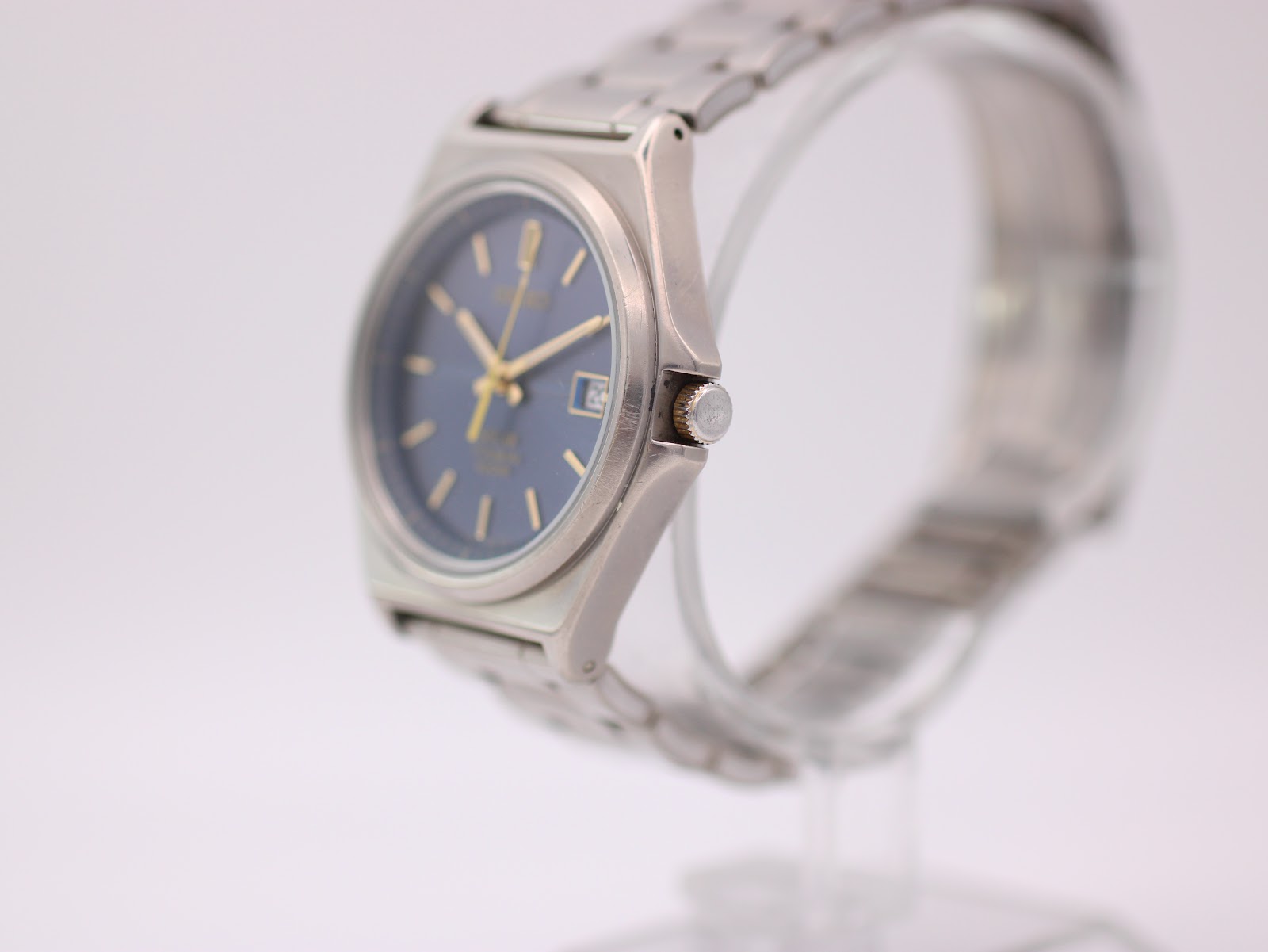 Right-side profile view of the Seiko titanium watch, showing the octagonal case and gold crown.