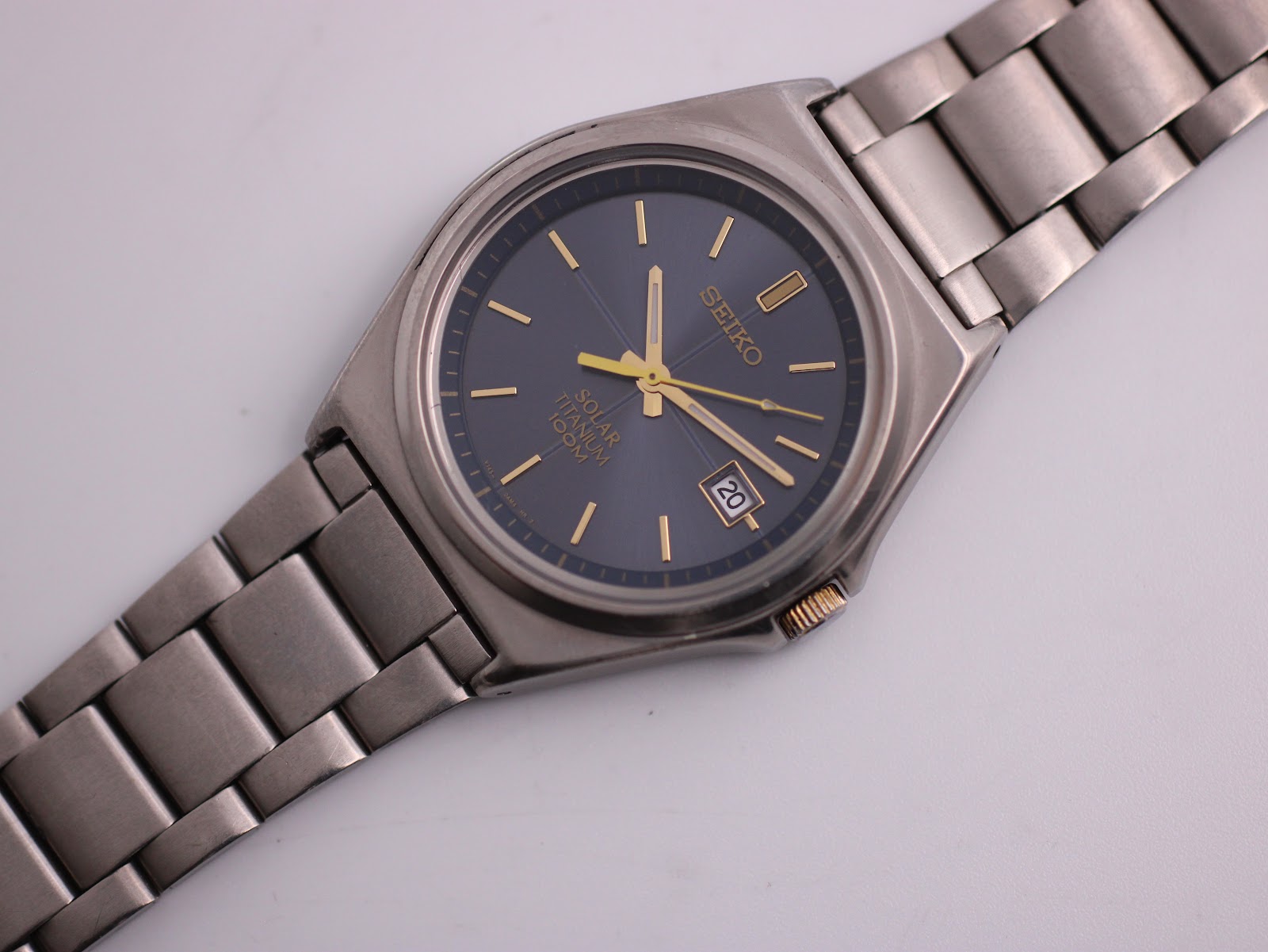 Overhead view of the Seiko solar titanium watch, displaying the blue dial and integrated titanium bracelet.