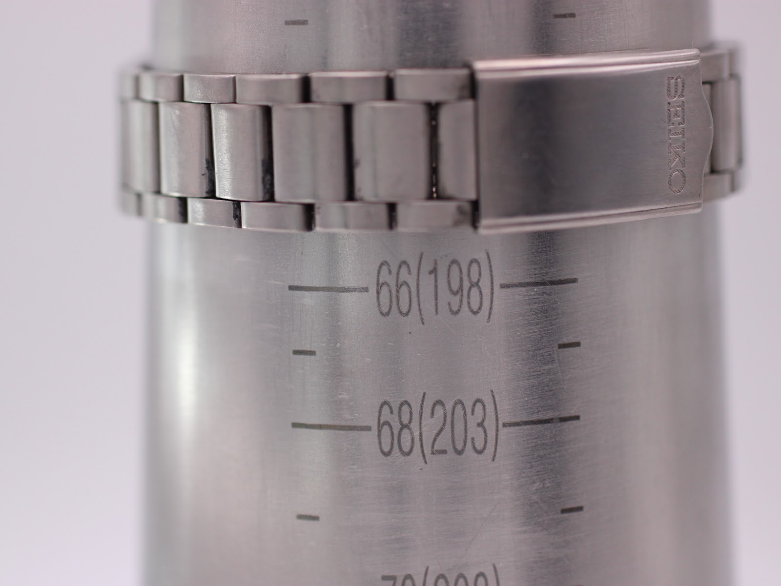 Close-up of the Seiko integrated bracelet on a wrist sizing gauge, showing a measurement of 198mm.