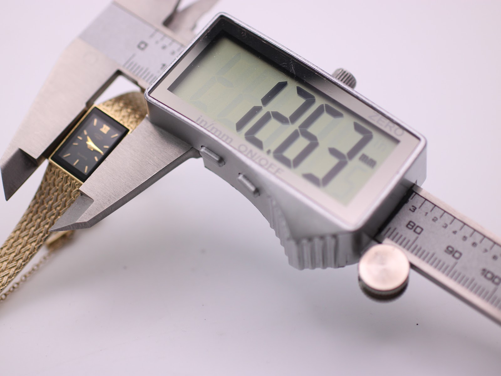 Close-up of the watch case back, a brushed metal surface with '1991' engraved.