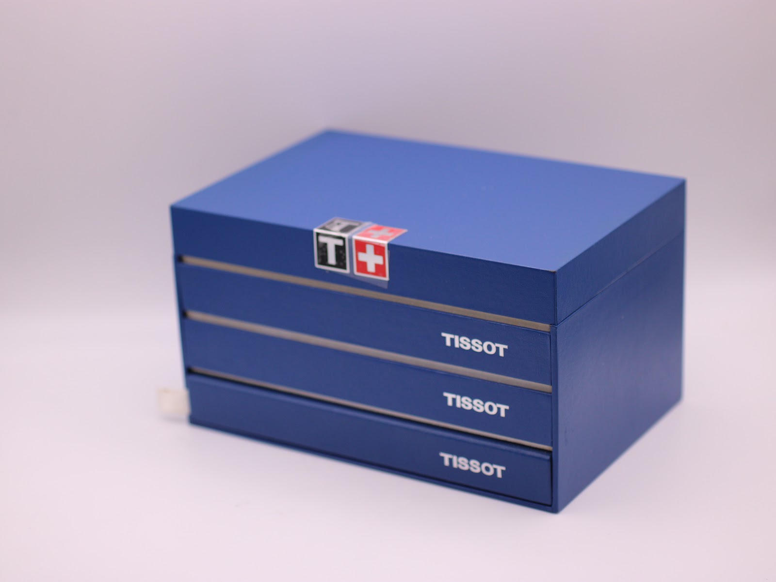 Original Tissot blue presentation box, closed, showing the Tissot logo and drawer design.