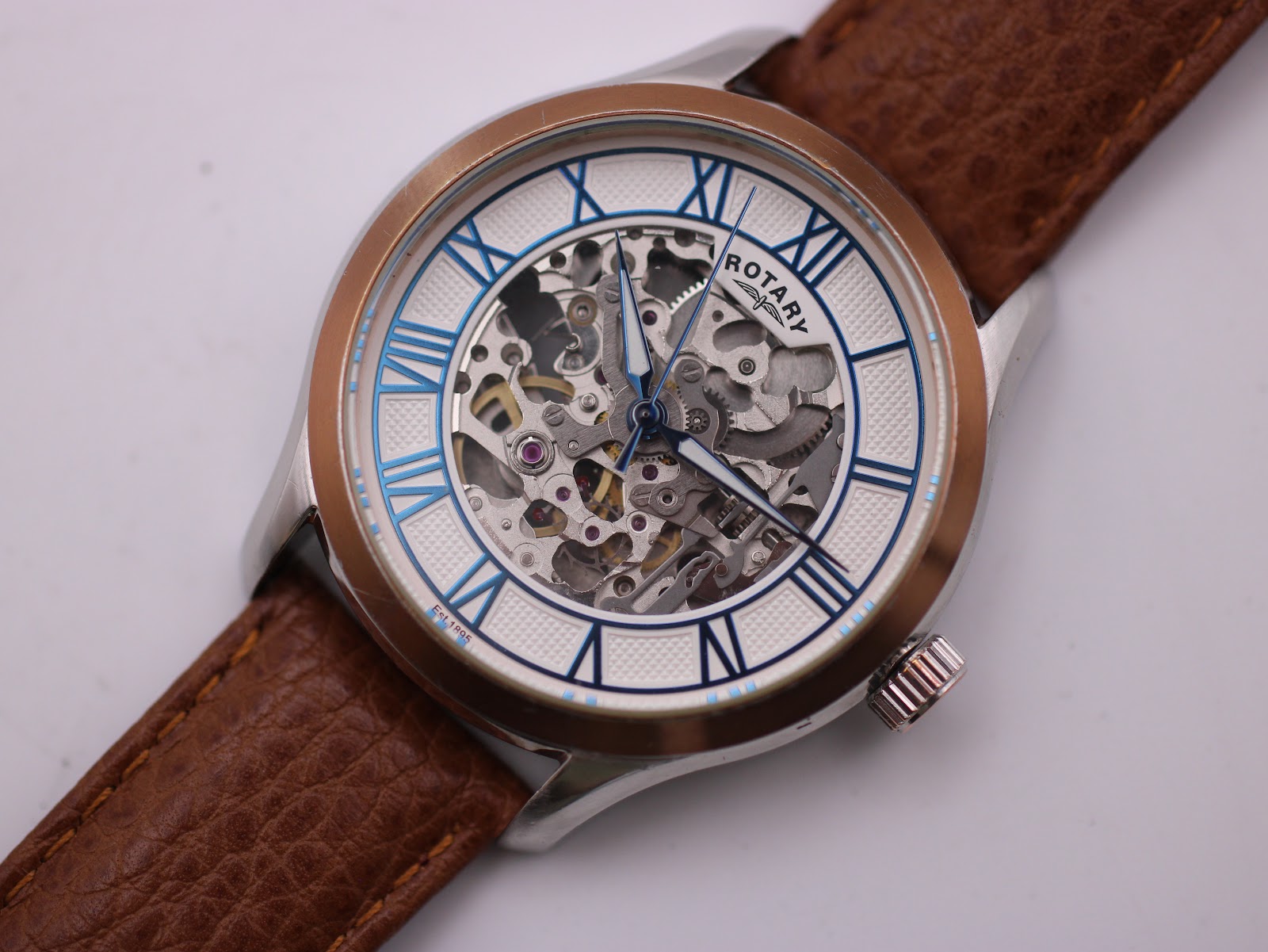 Close-up front view of the Rotary skeleton dial with blue Roman numerals and visible automatic movement.