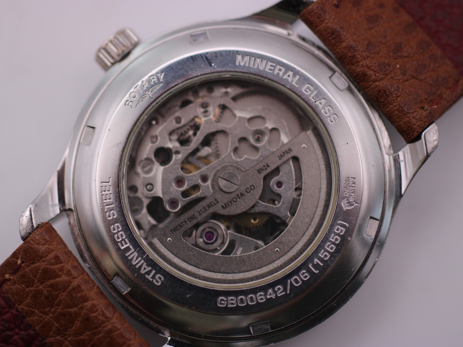 Close-up of the display case back, showing the Miyota automatic movement, model number, serial, and "mineral glass" inscription.