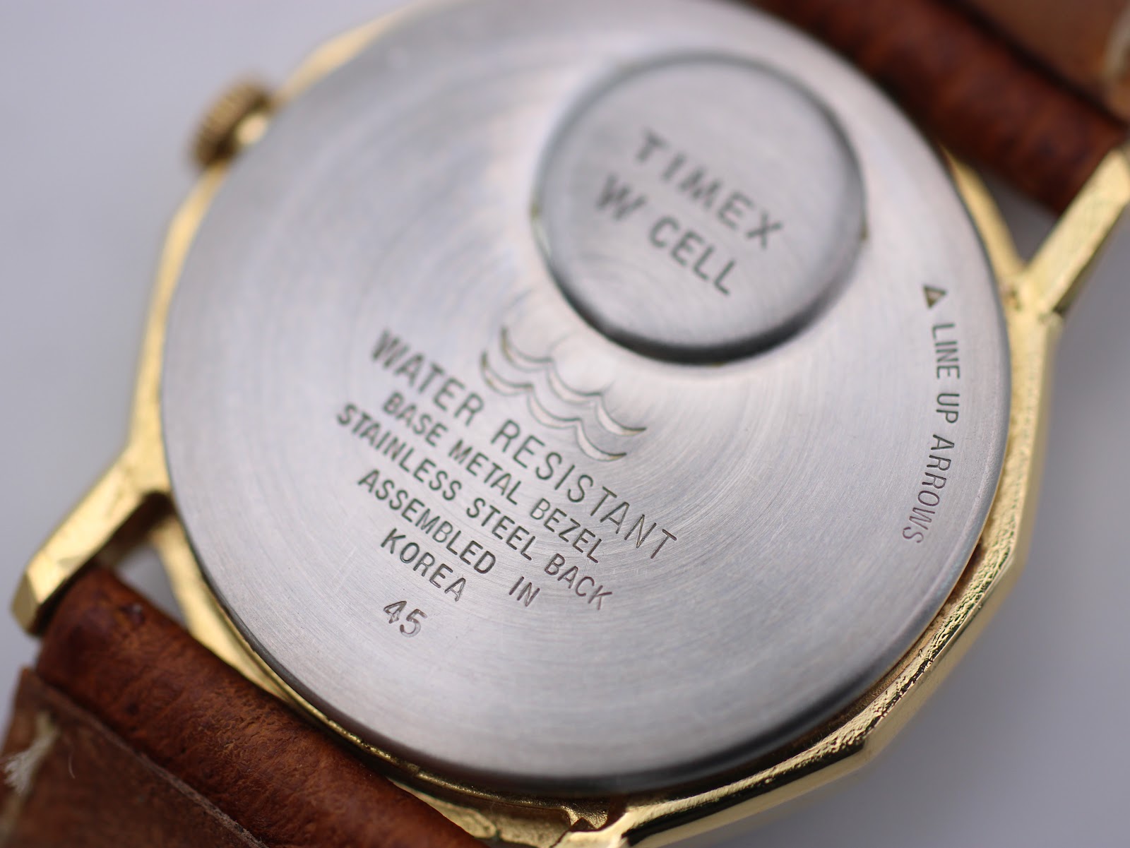 Extreme close-up of the watch case back, showing 'Timex W Cell', 'Assembled in Korea', and 'Water Resistant' text.
