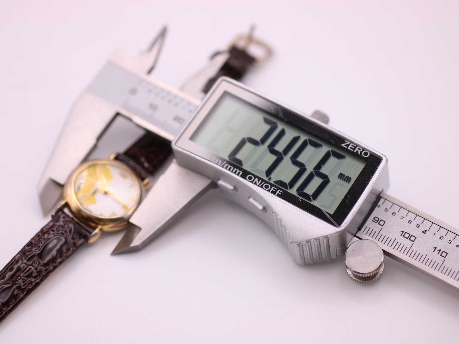 Digital caliper measuring the watch case diameter at 24.56mm.