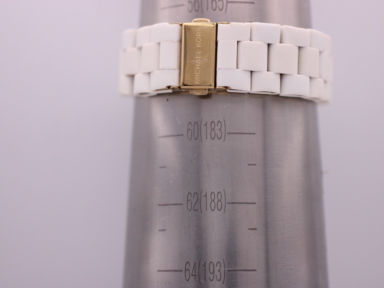 The Michael Kors watch bracelet closed on a wrist sizing gauge, indicating a wrist circumference of approximately 18.5 cm.