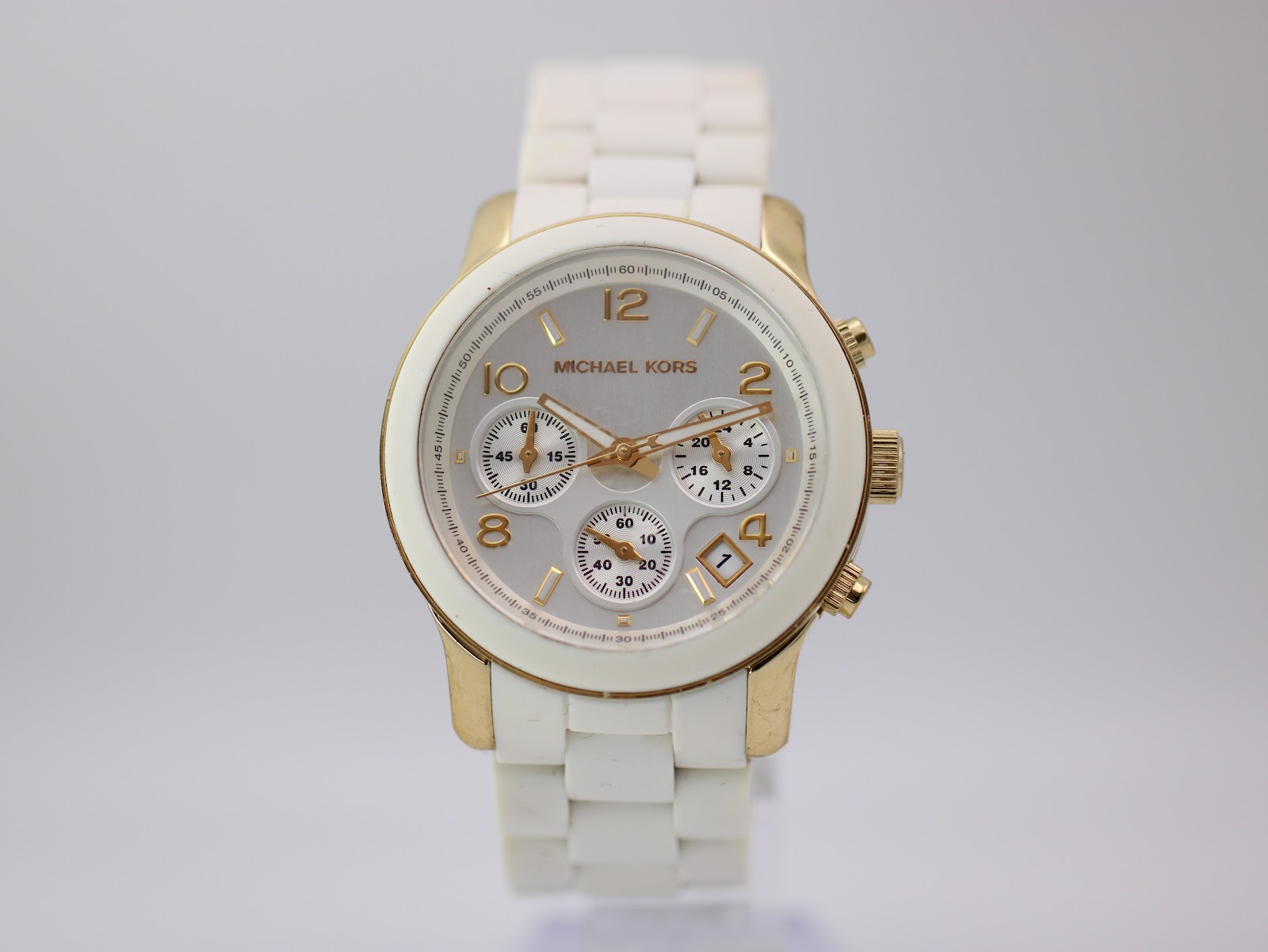 Direct front view of the Michael Kors MK-5145 dial, clearly showing the white face, gold numerals, subdials, and date window.