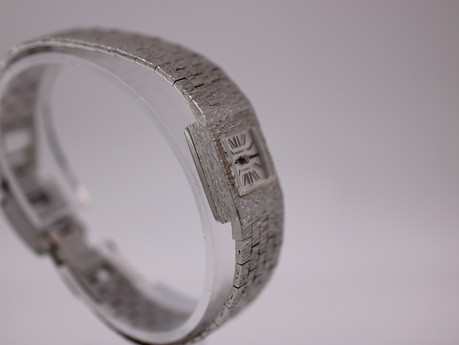 Angled side view of Regency watch on a display stand, highlighting the bracelet.