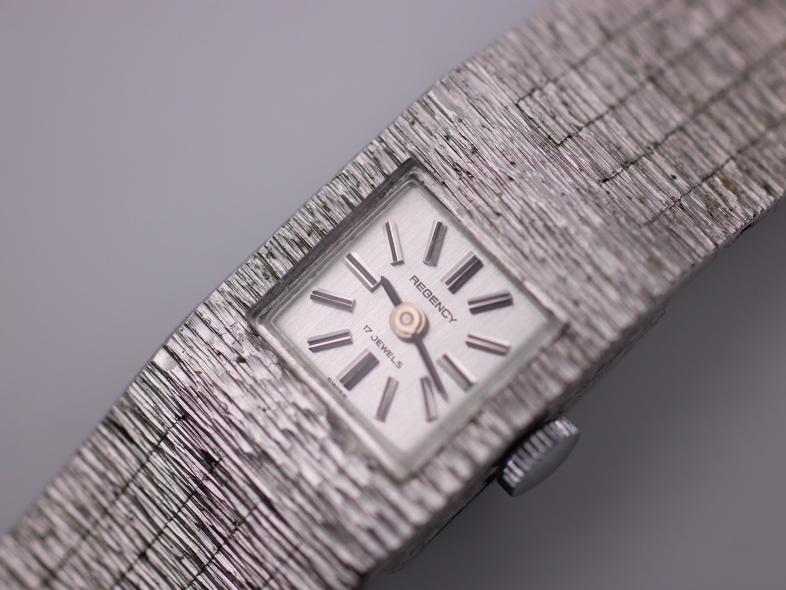 Close-up of the square silver-tone dial with 'REGENCY' and '17 JEWELS' text, showing baton indices.