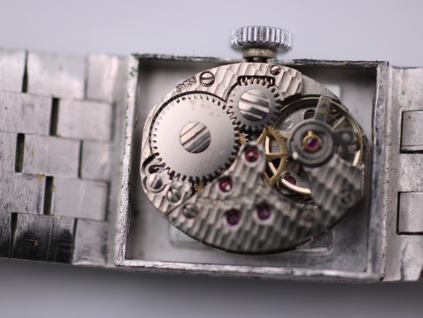 Open case back view revealing the mechanical manual wind movement with visible gears and jewels.