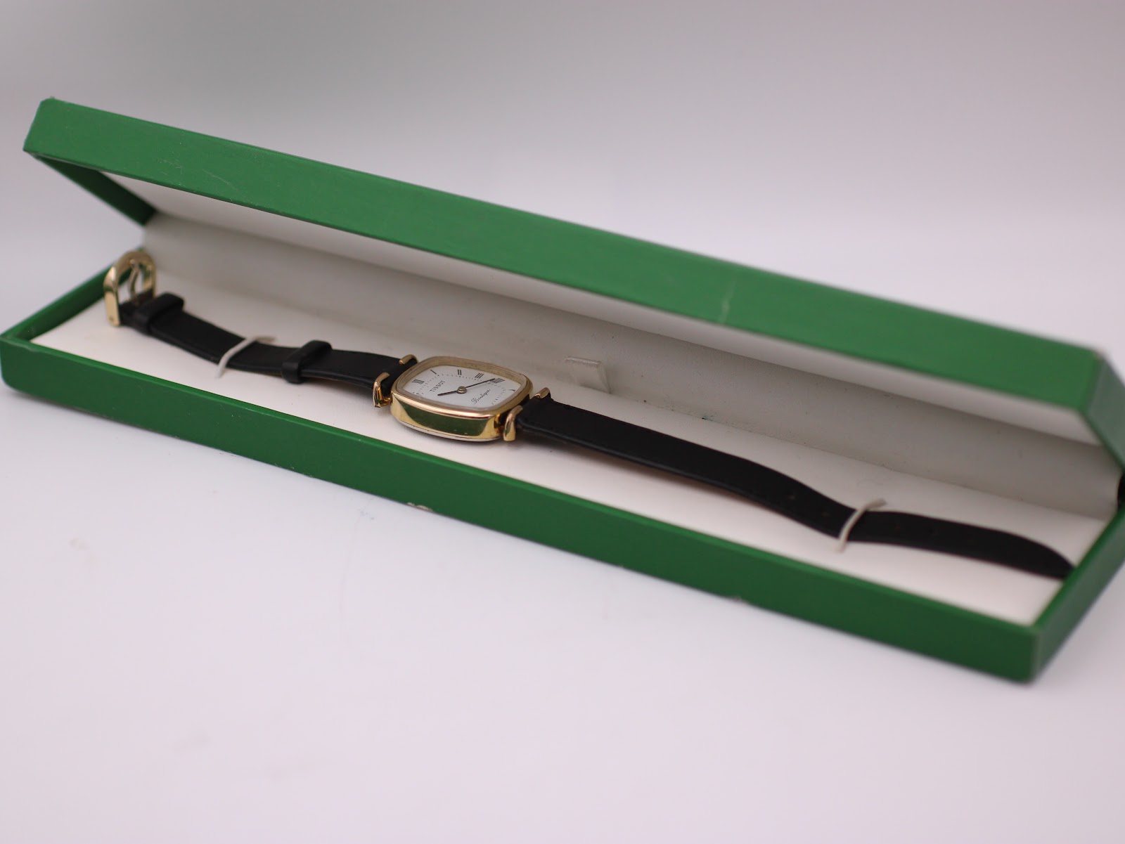 The Tissot Boutique watch displayed inside a generic green presentation box.