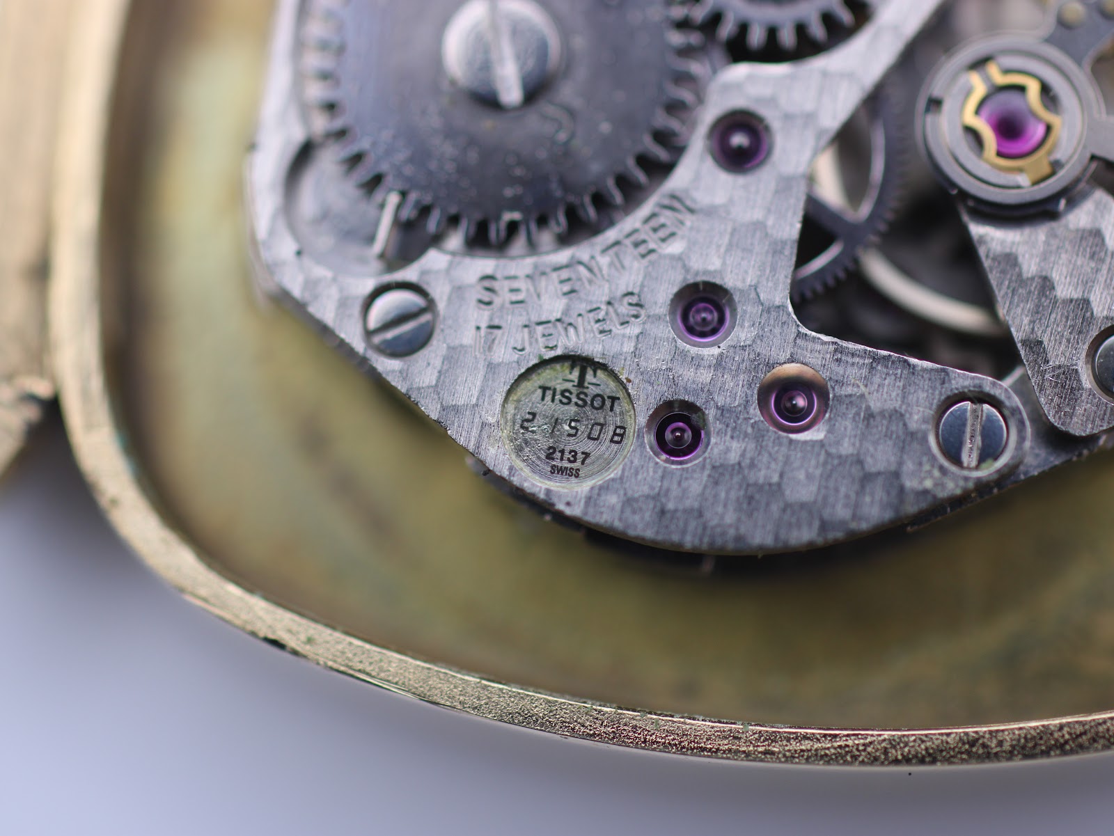 Macro close-up of the manual wind movement, showing 'TISSOT', 'SEVENTEEN 17 JEWELS', and movement calibre details.