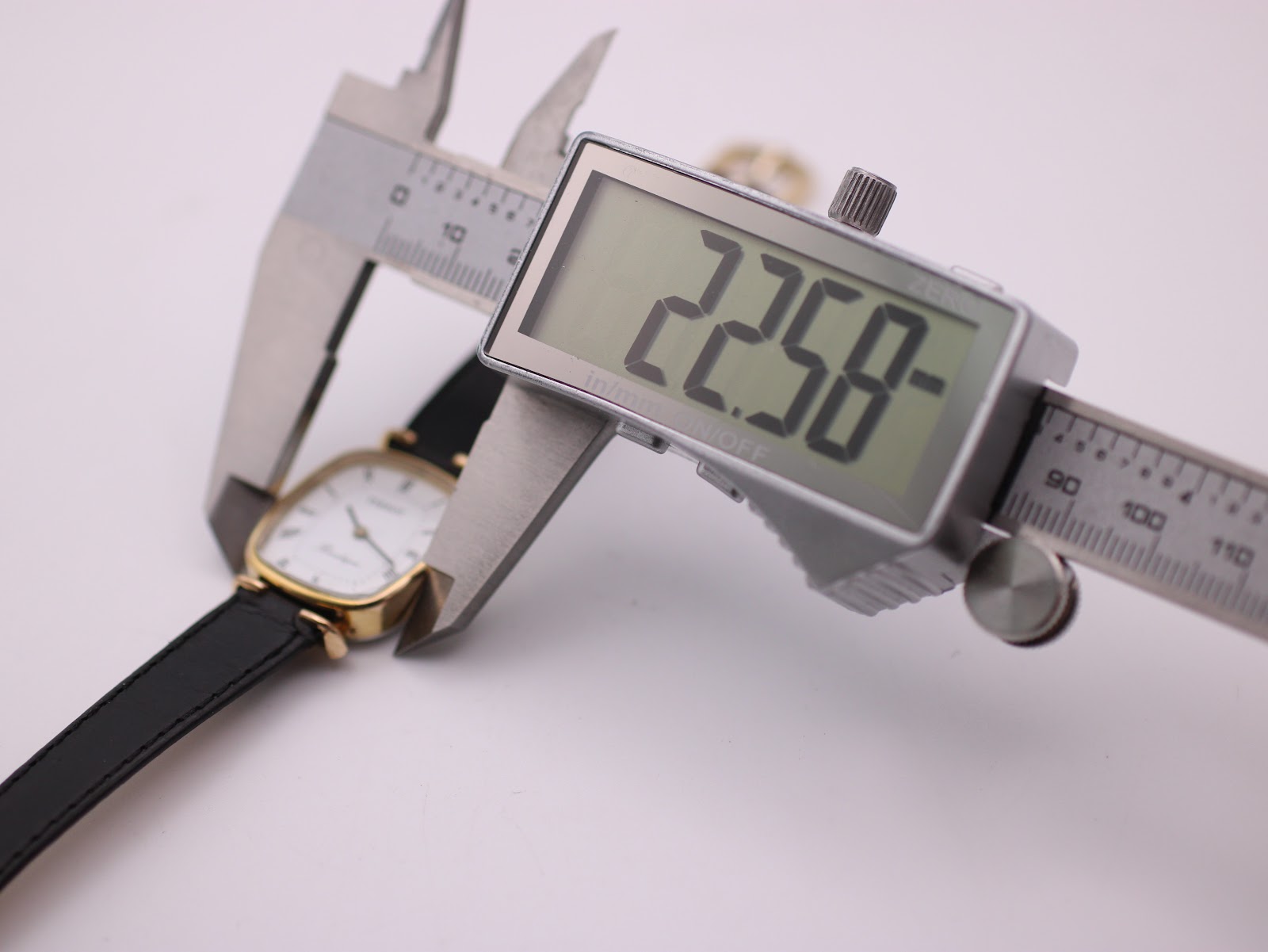 Digital caliper measuring the case diameter of the Tissot watch at 22.58mm.